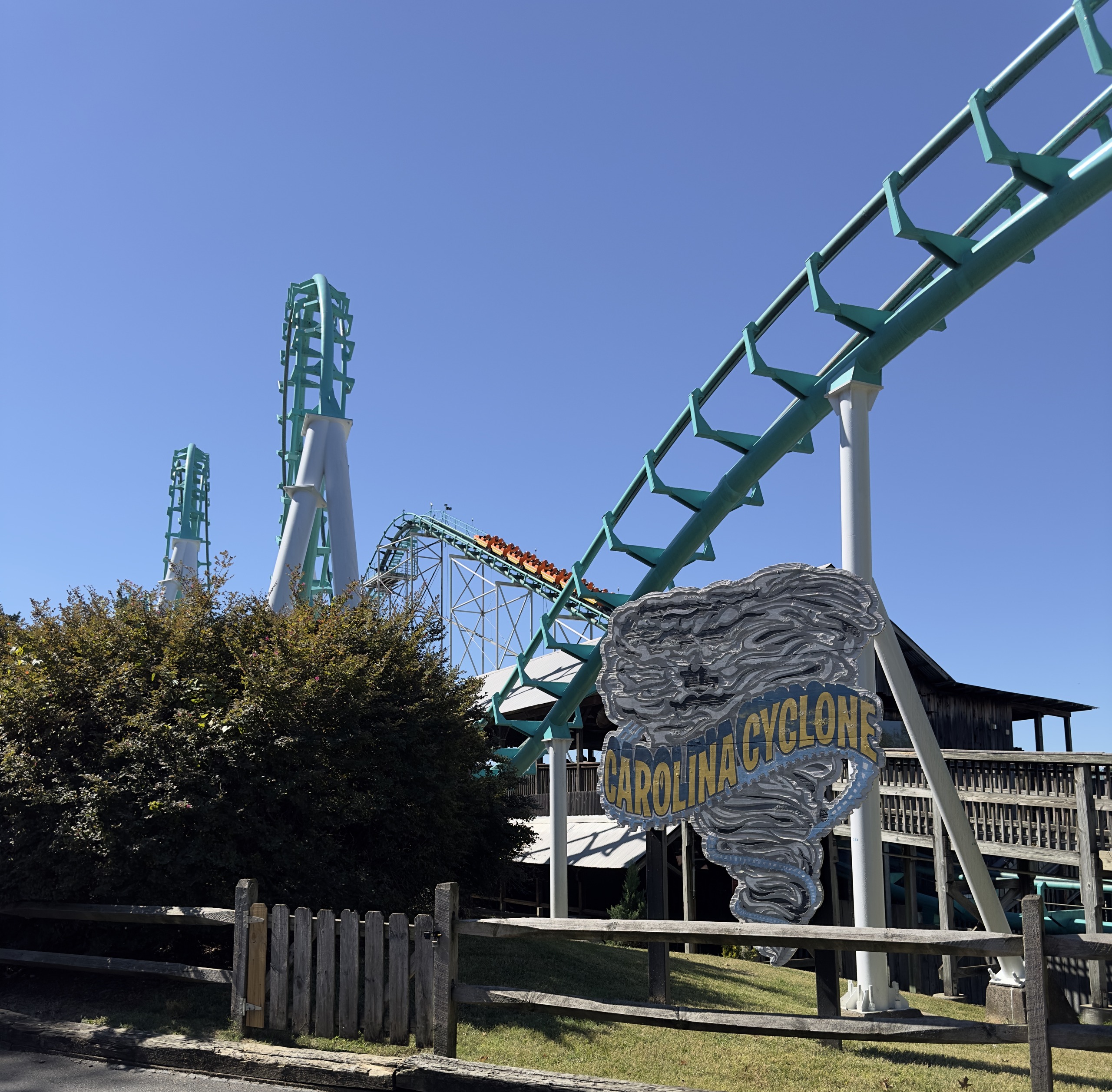 The Carolina Cyclone tornado sign in front of the teal track, loops and wooden station building, Carowinds, October 2024