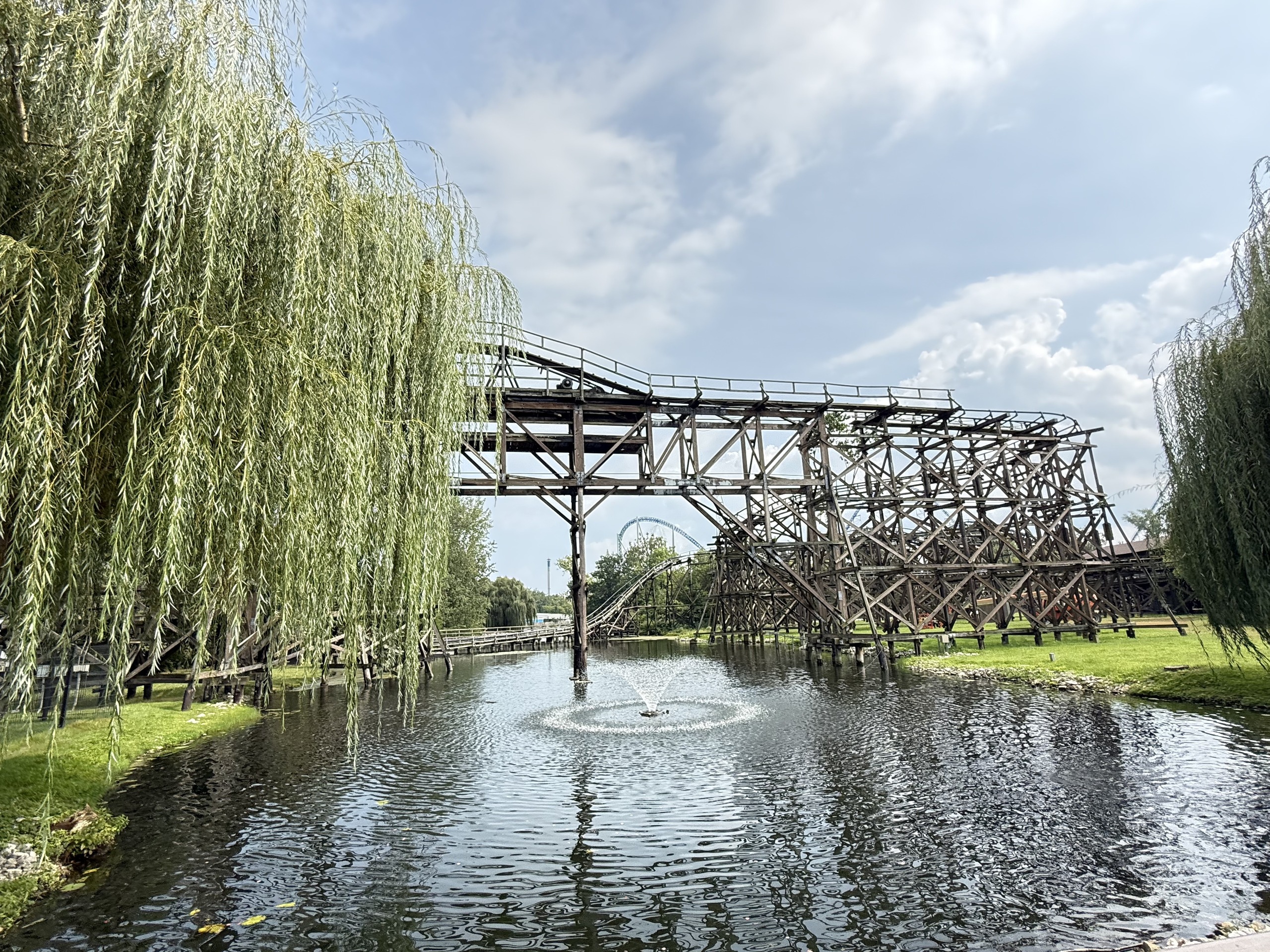 Cedar Creek Mine Ride's wooden structure and helix over the lagoon and fountain
