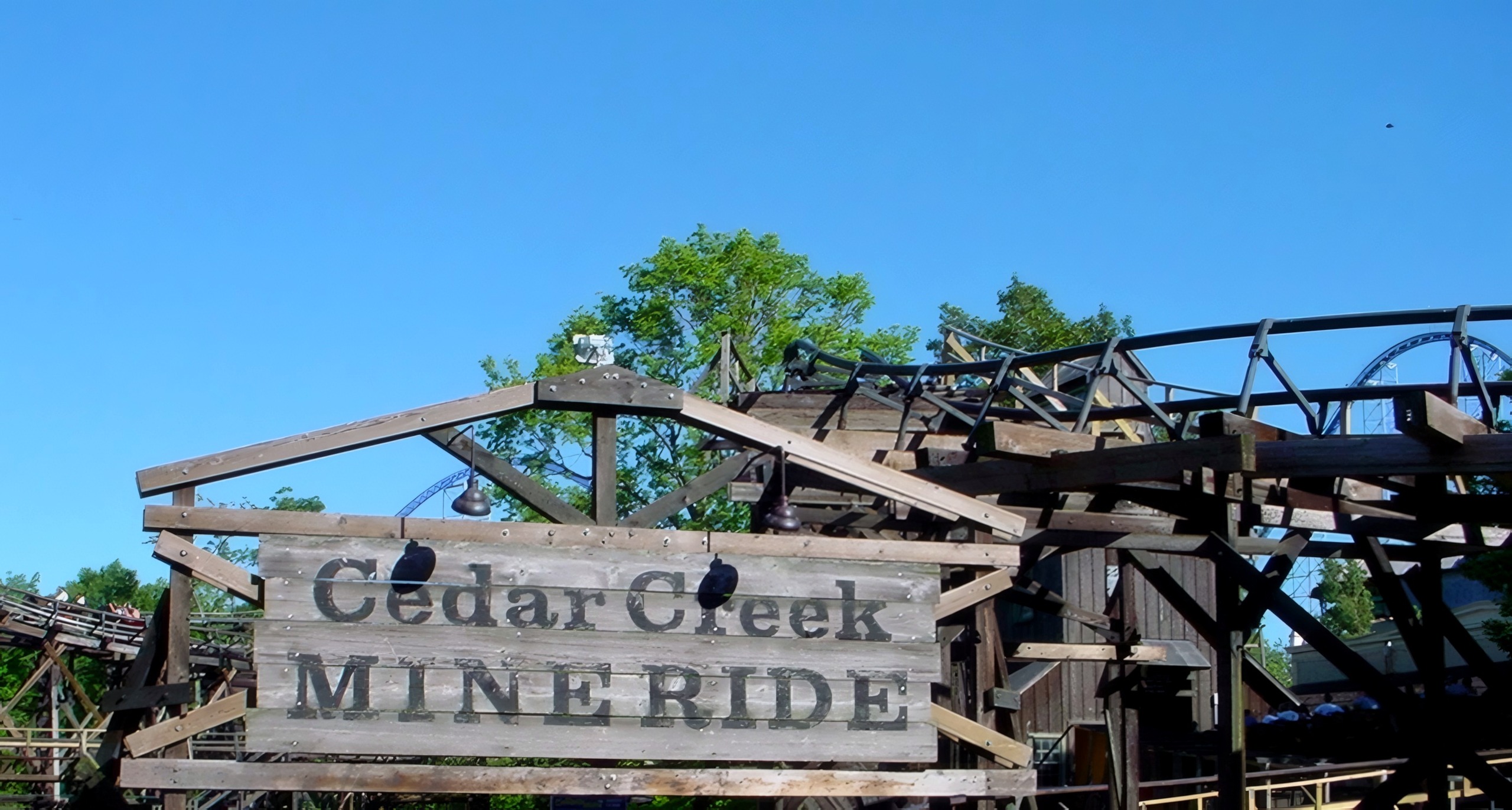 The Cedar Creek Mine Ride entrance sign in front of the wooden trestle at Cedar Point, July 2003