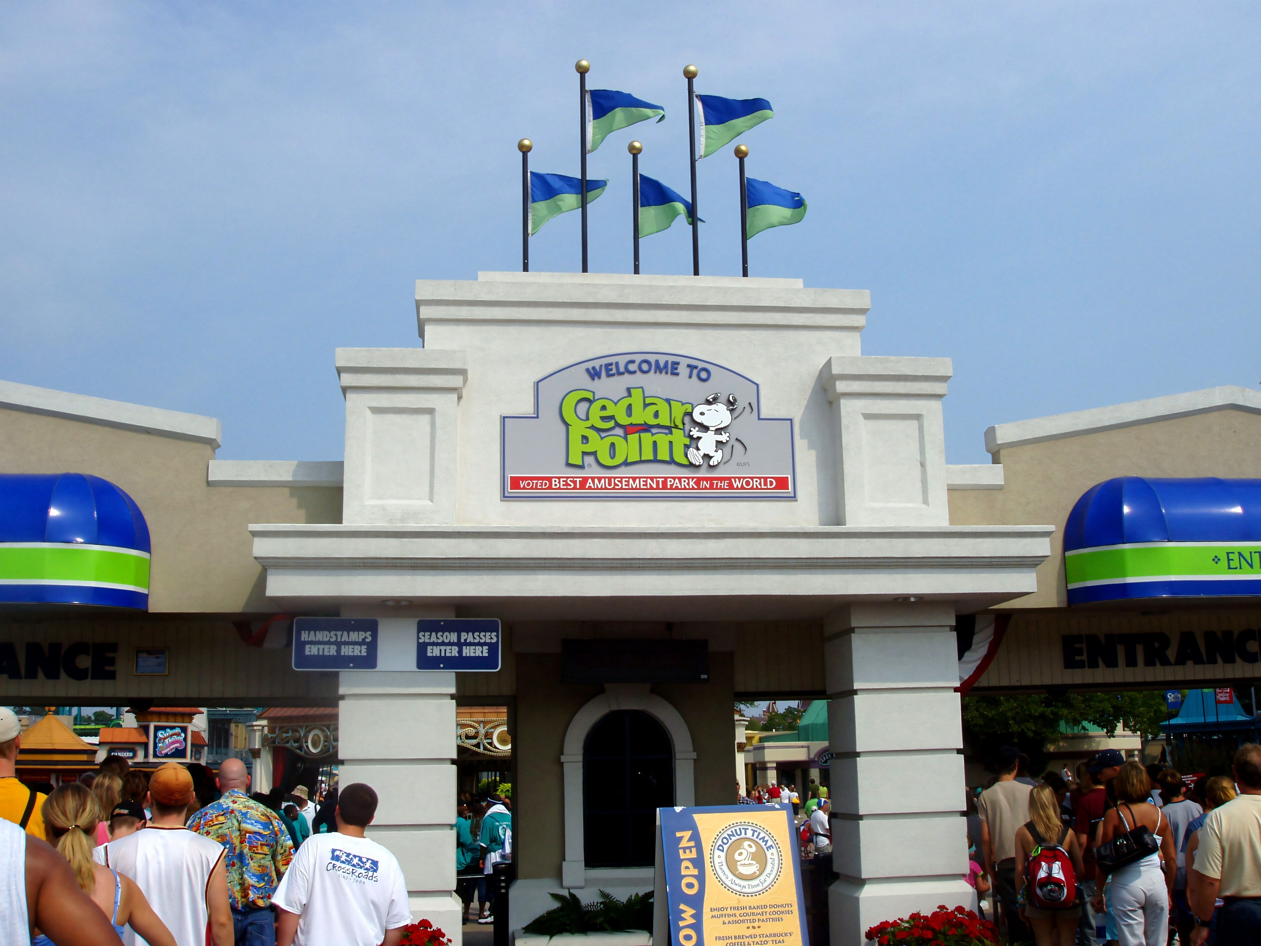 The Welcome to Cedar Point main entrance sign with flags above the crowd at Cedar Point, July 2005