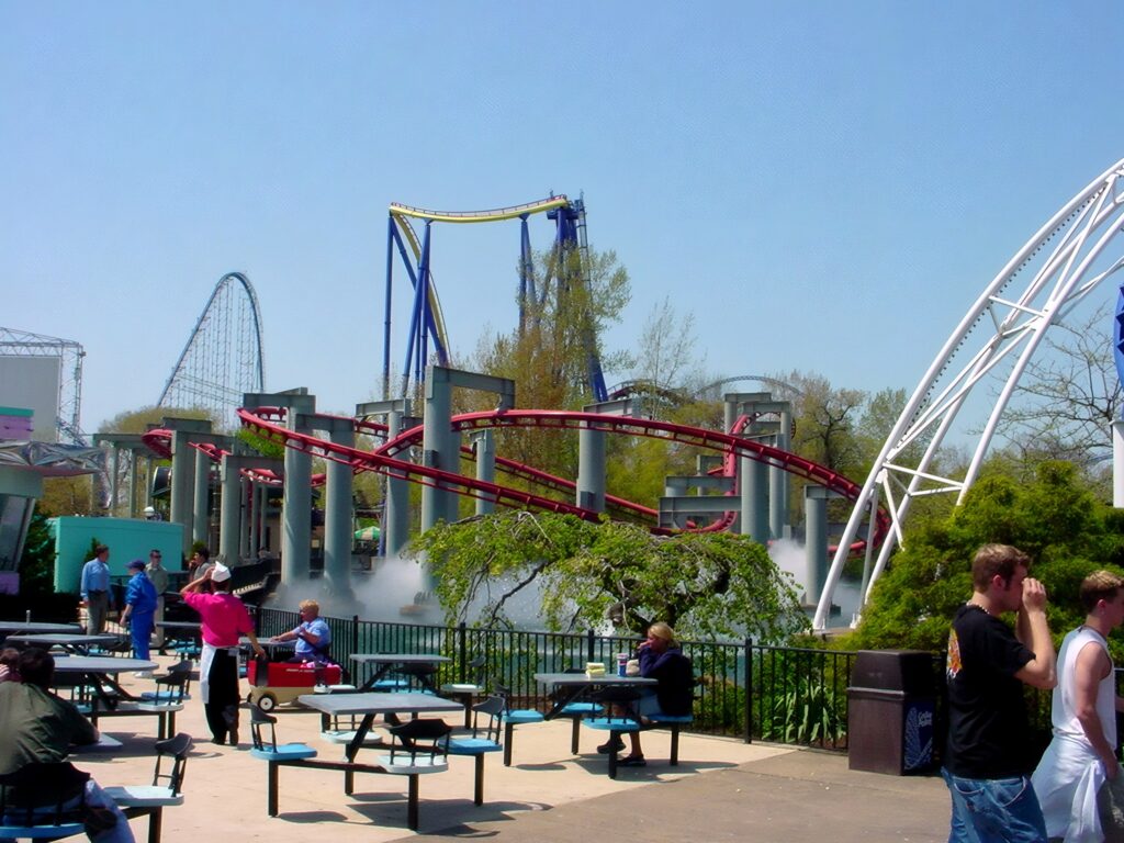 Magnum XL-200 and Wicked Twister rising behind Iron Dragon's track and a picnic area at Cedar Point, May 2002