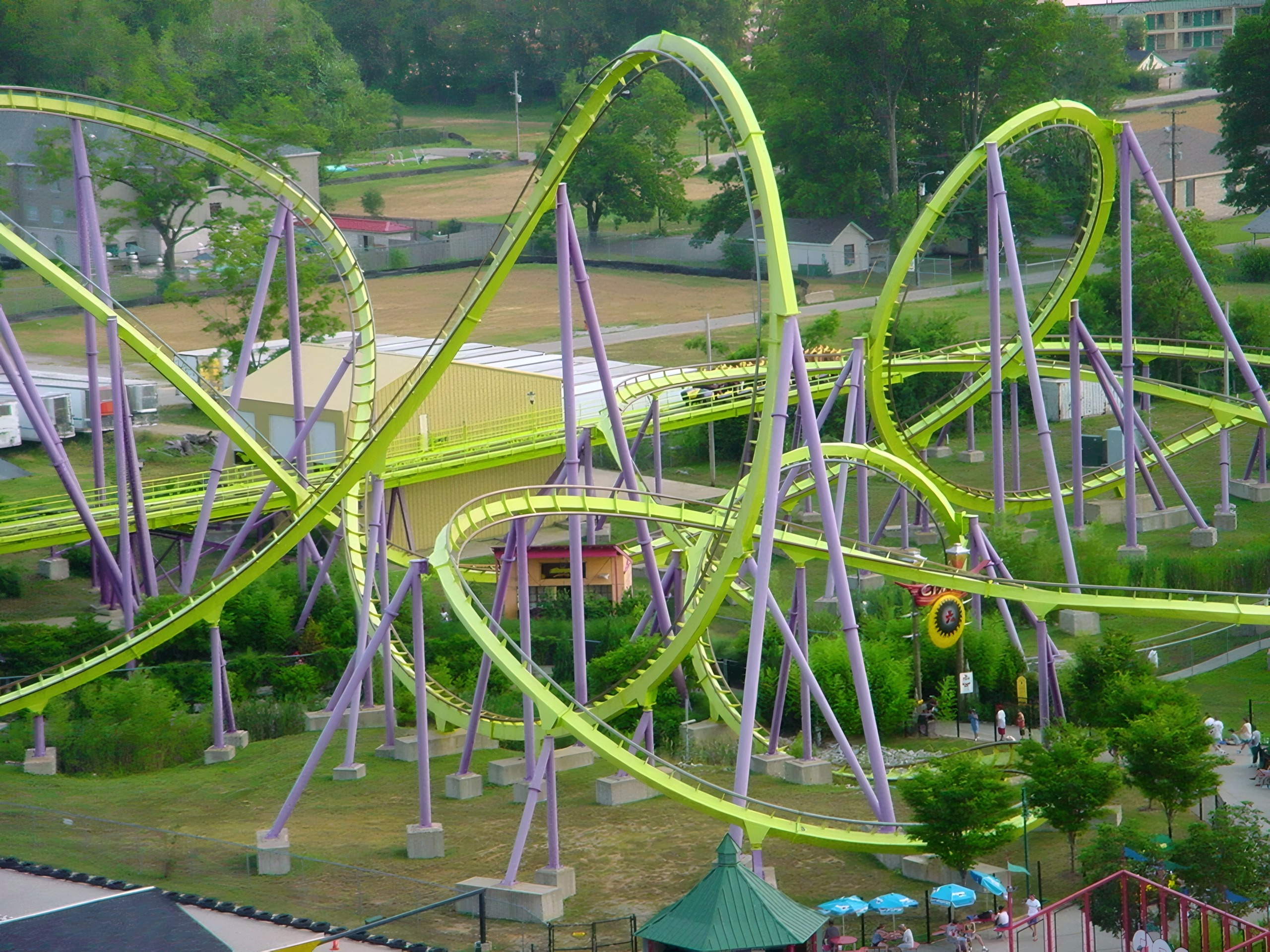Aerial view of green-and-purple looping steel coaster amid trees, Chang, July 2002