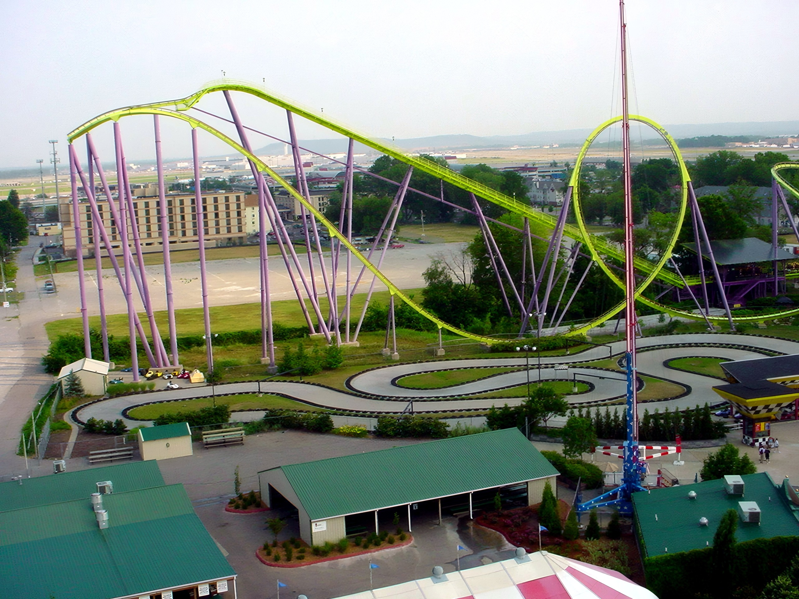 Aerial view of lime-green looping coaster near airfield, go-karts below, Chang, July 2002