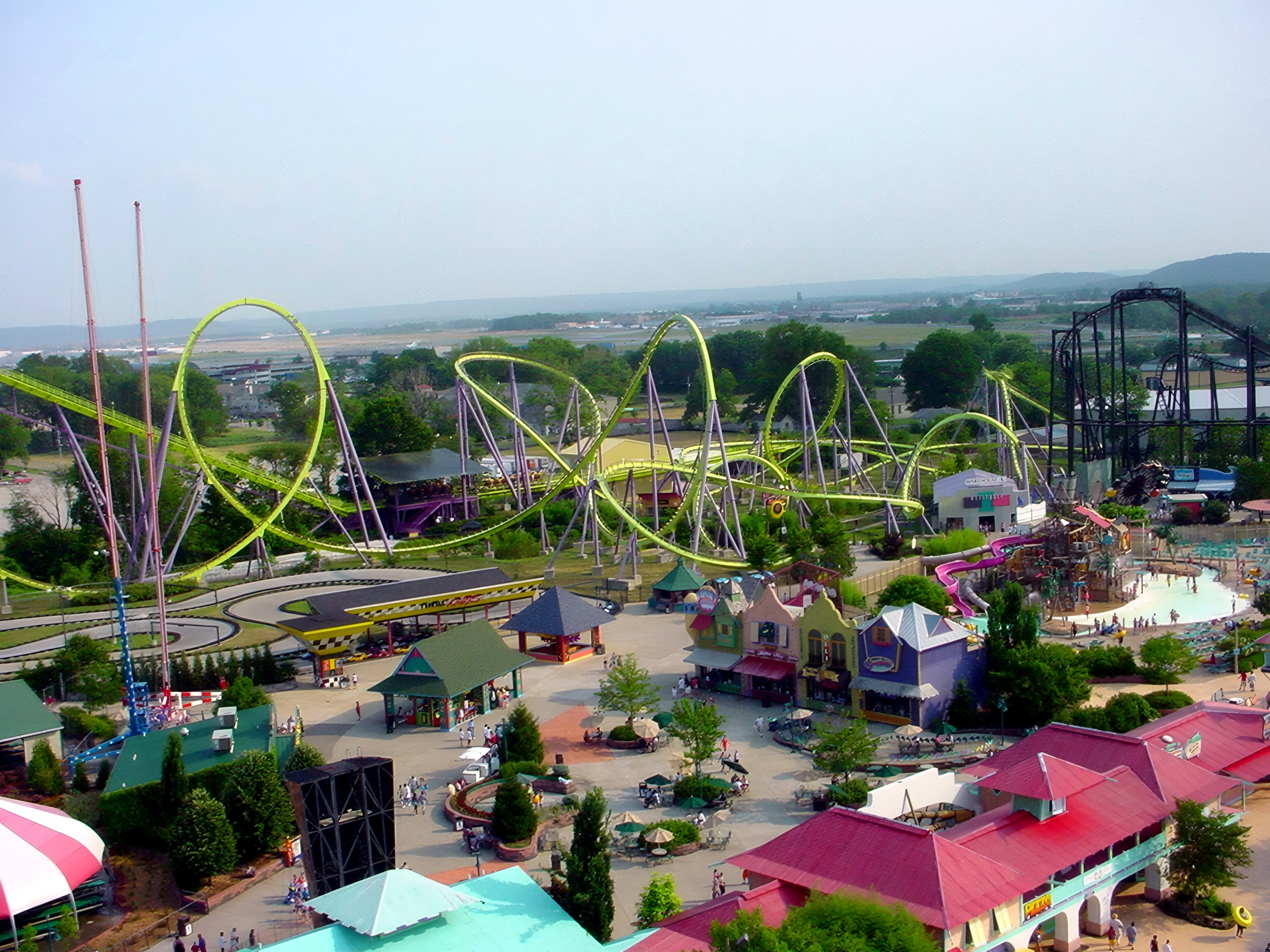 Aerial view of yellow steel looping coaster over midway, Chang, July 2002
