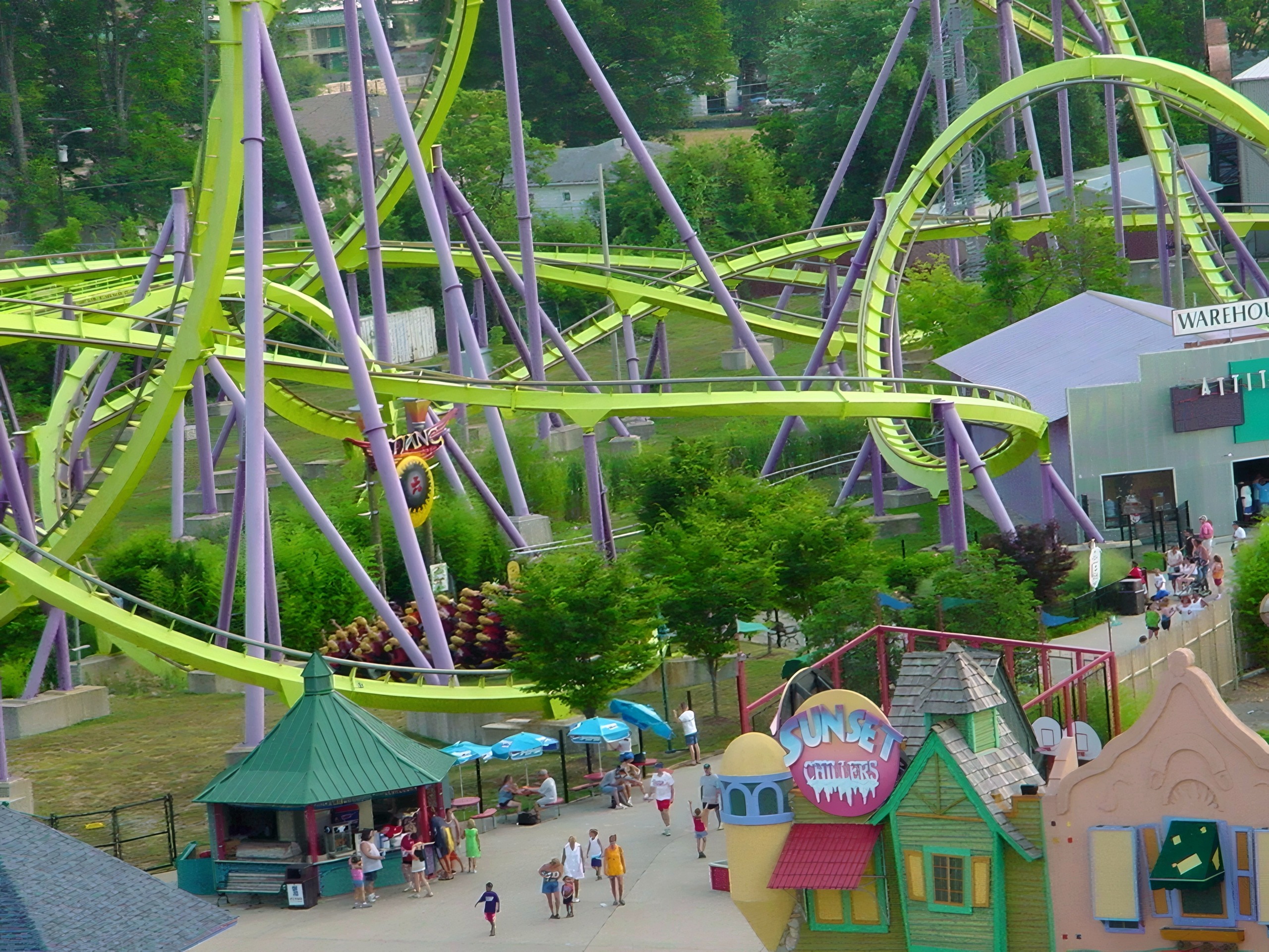 Coaster loops over midway with visitors walking below, Chang, July 2002