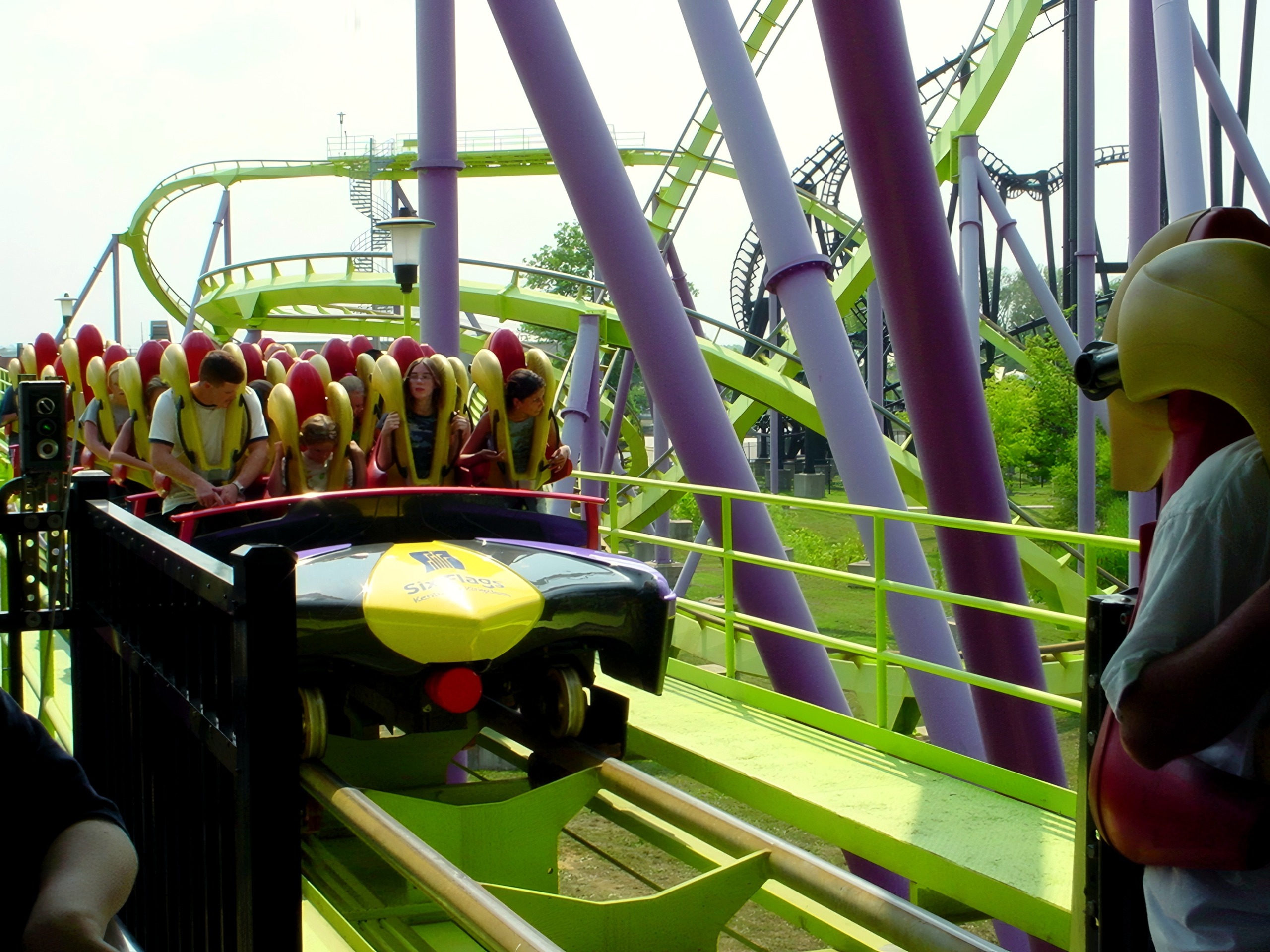 Riders in stand-up coaster train at station, Chang, July 2002