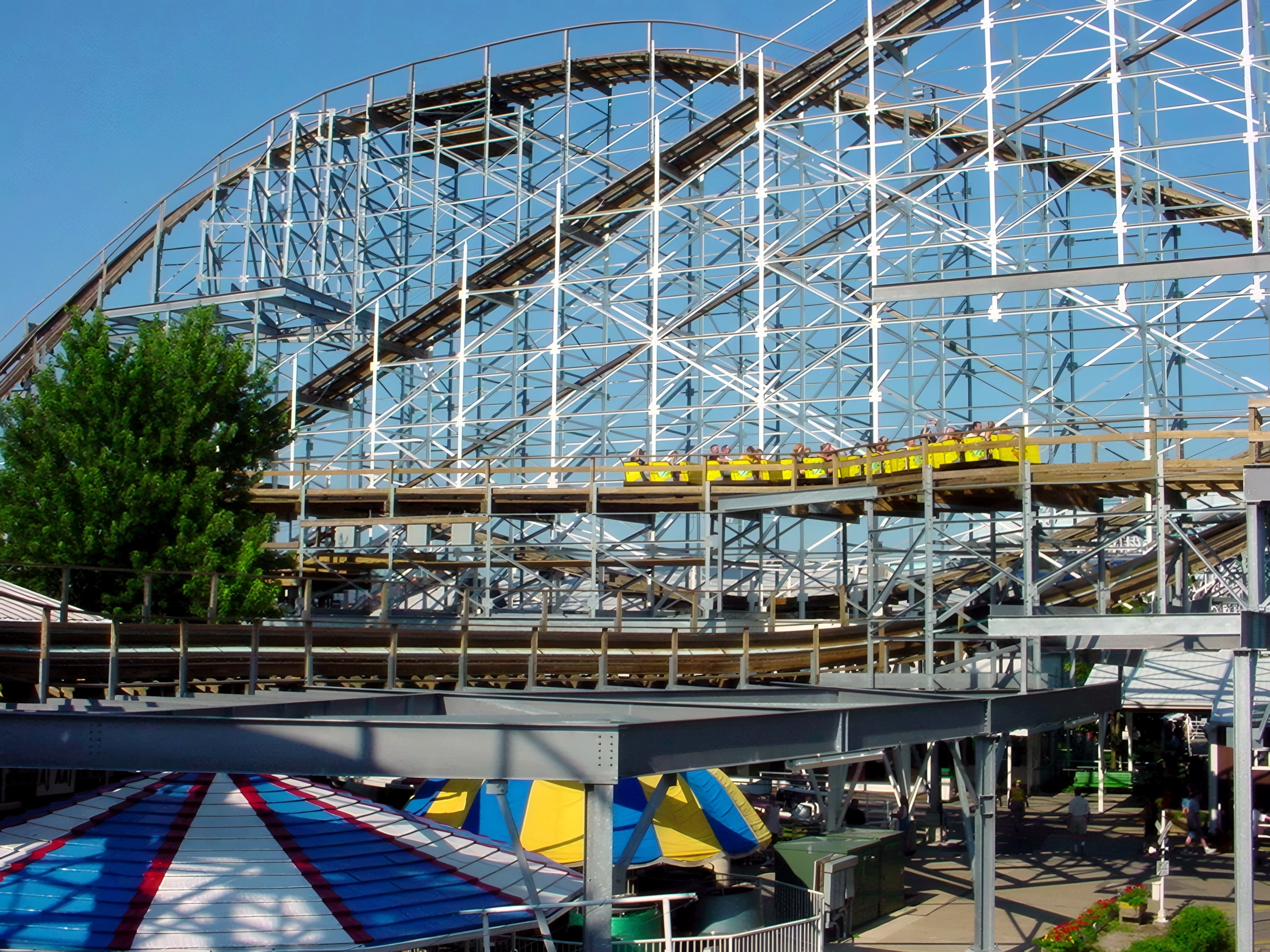 A Cornball Express yellow train running above the midway tents, June 2002