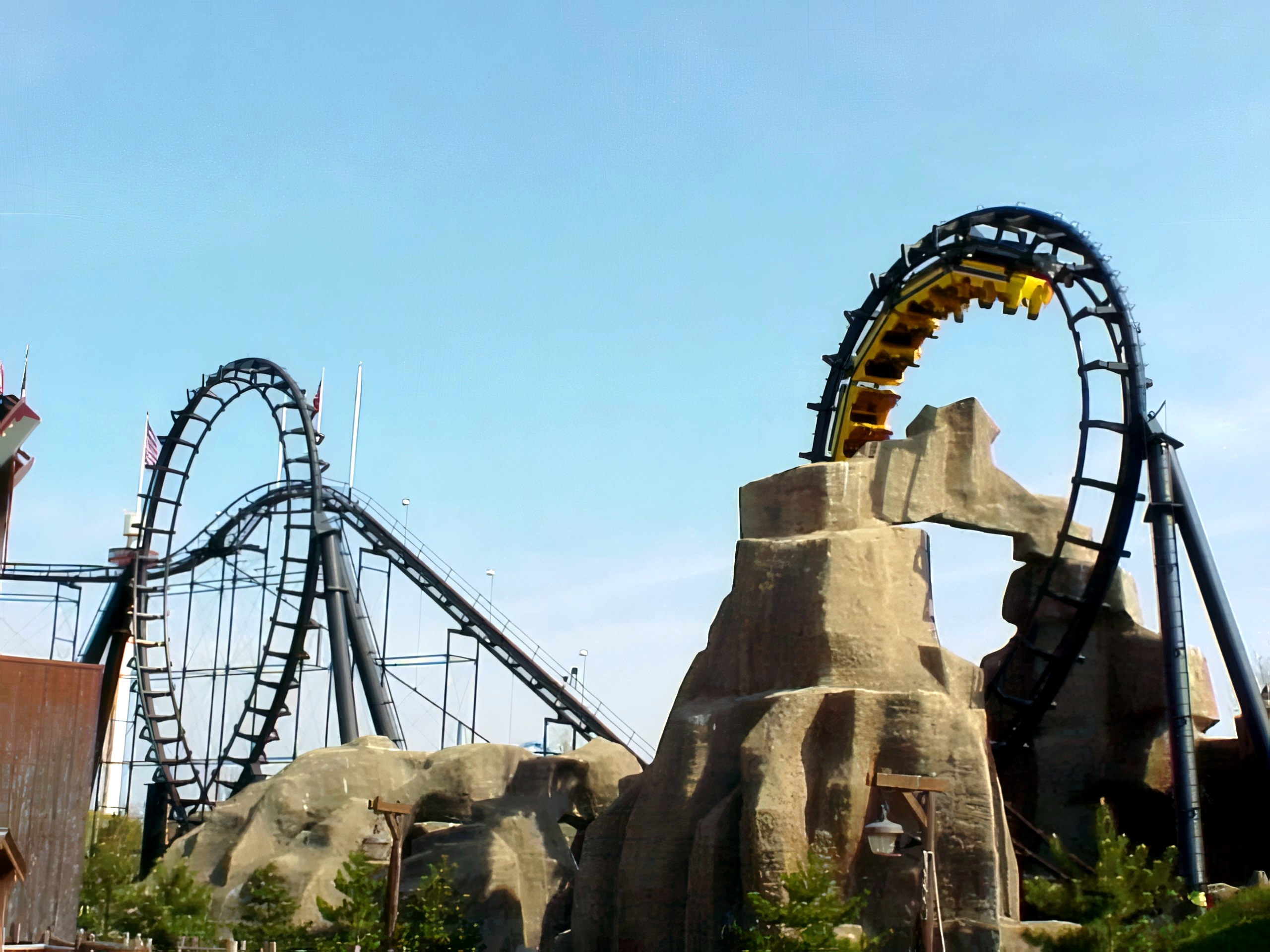 A Demon train in the second vertical loop above the themed rockwork, with the first loop at left at Six Flags Great America, April 2000