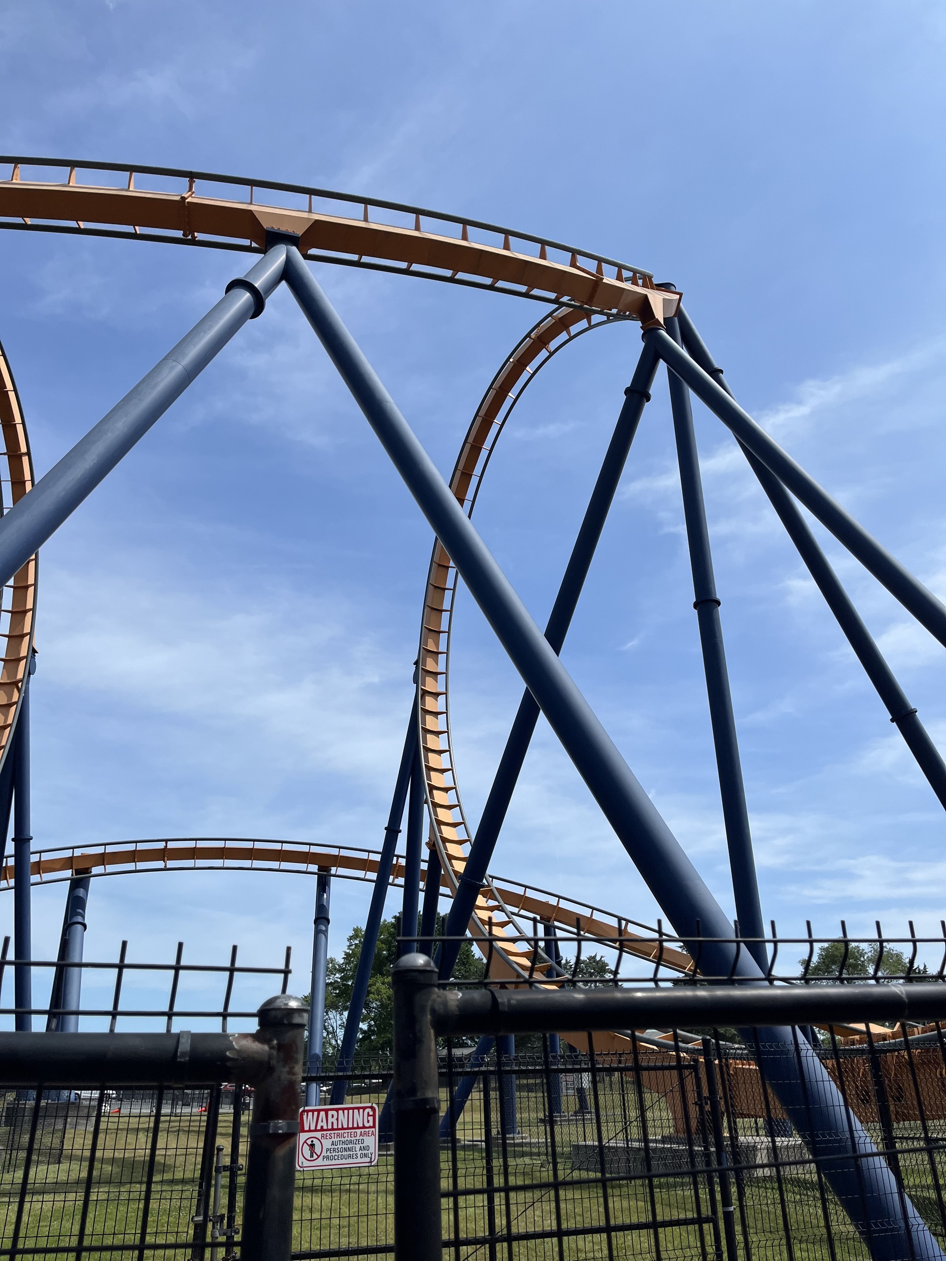 Dominator's orange track and dark blue supports against the sky at Kings Dominion, 2023