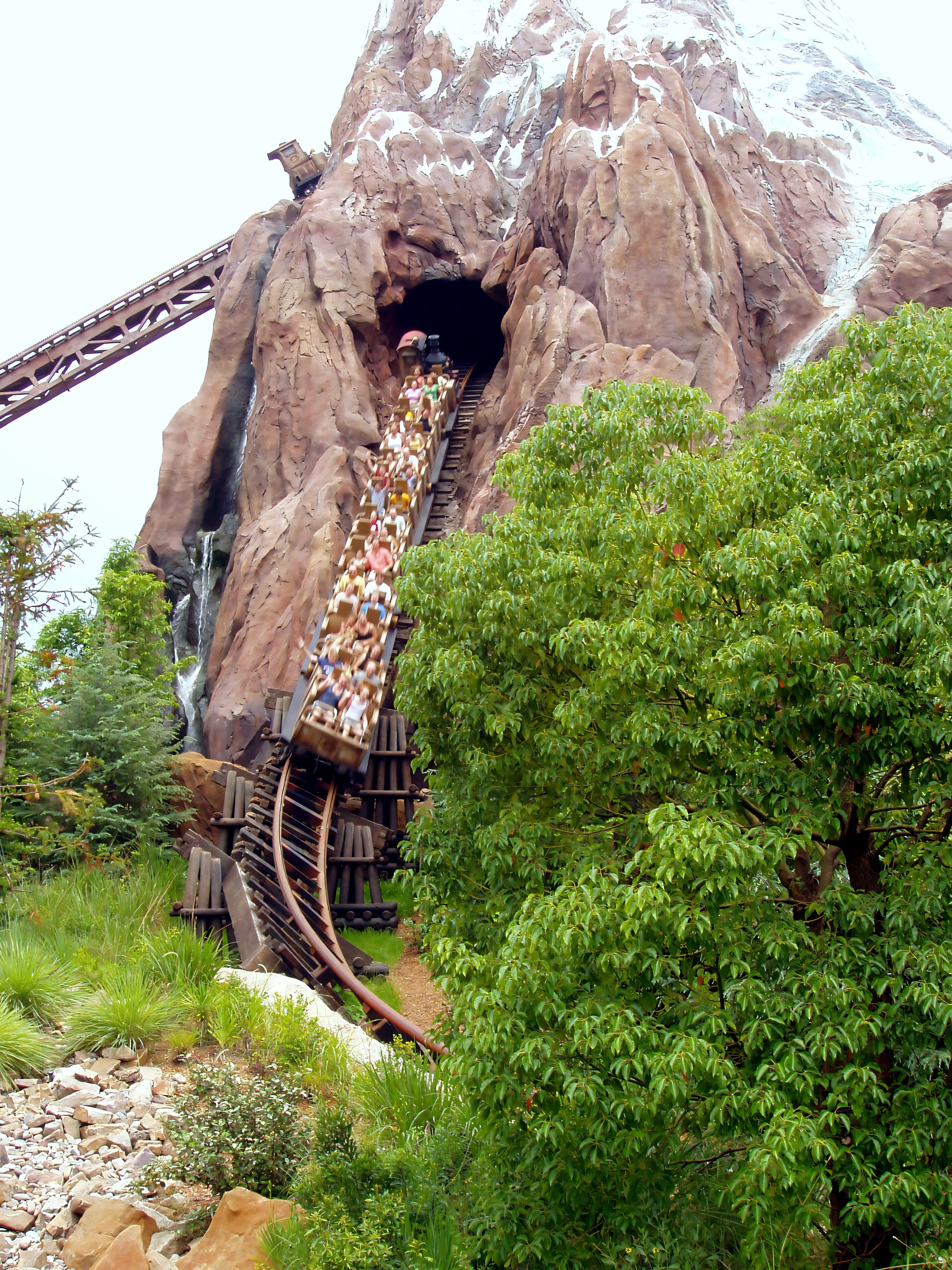 Coaster train entering mountain tunnel, full of riders, Expedition Everest