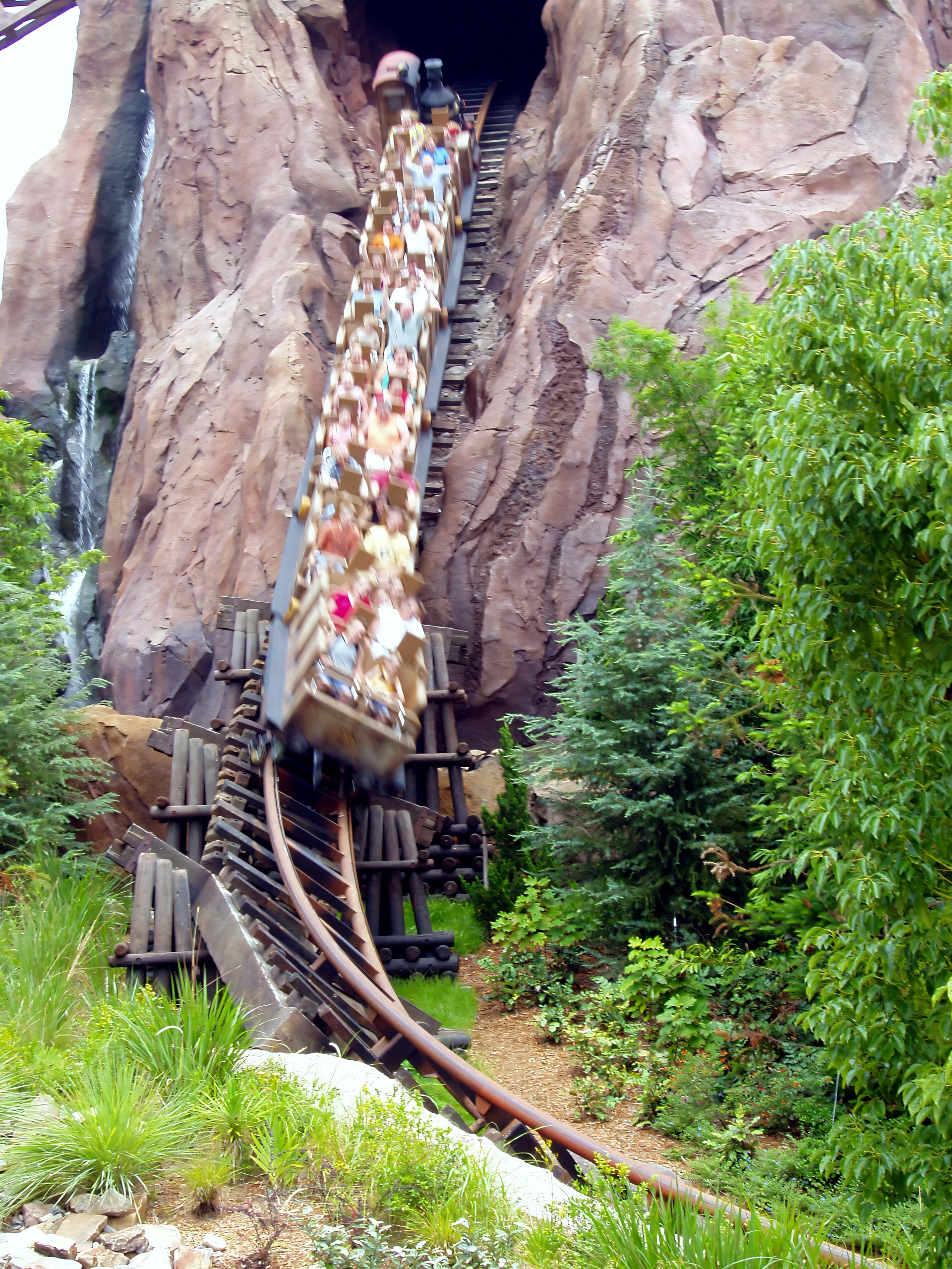 Coaster train speeding down track, motion-blurred riders, Expedition Everest