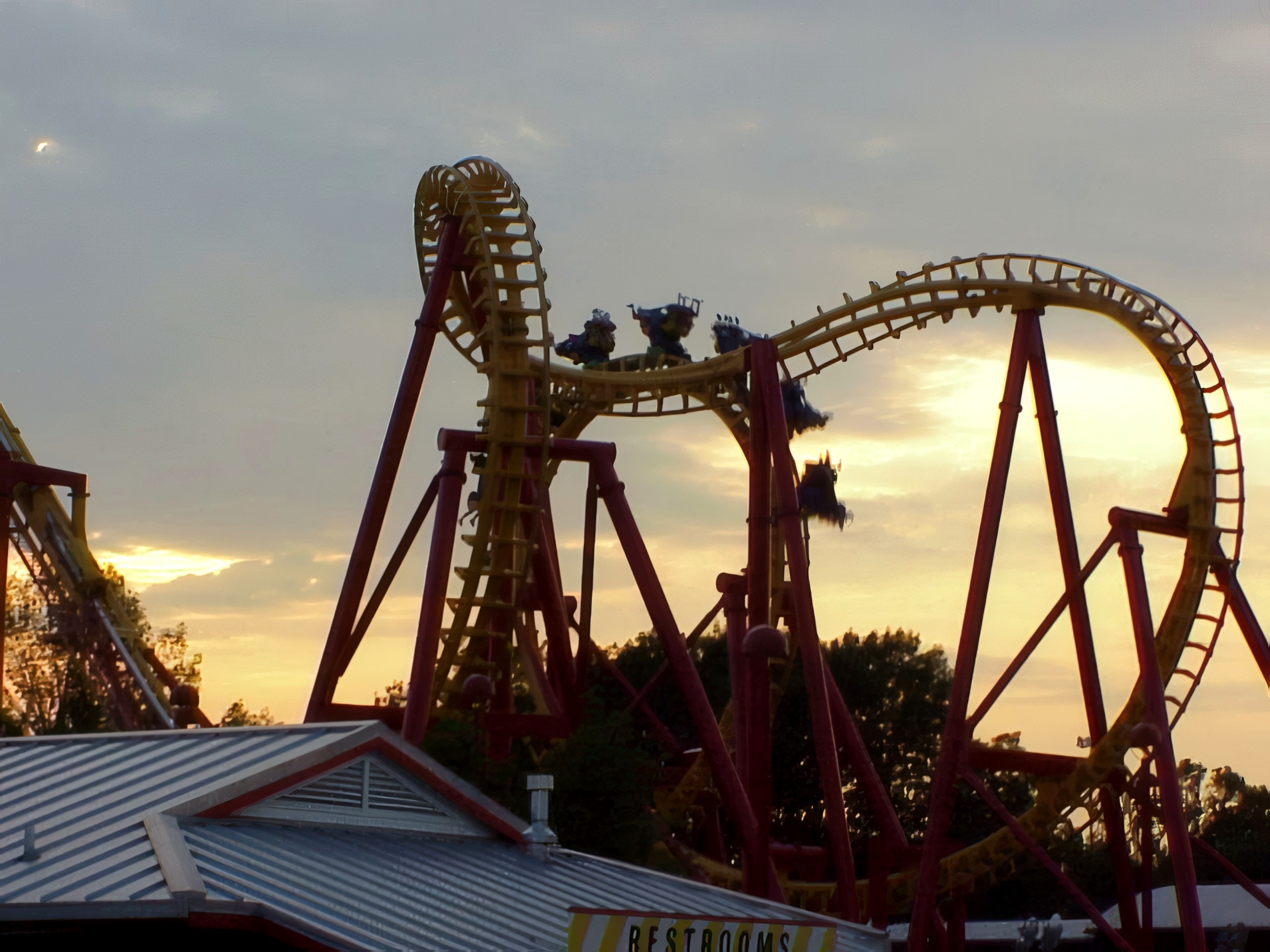 Hanging riders on Face/Off silhouetted at sunset at Kings Island, August 2000