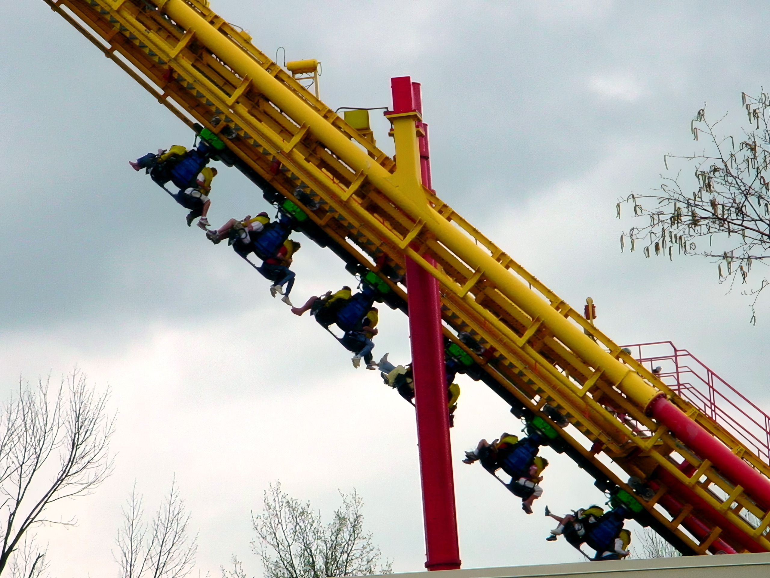 Riders dangling from a Face/Off train on the lift spike at Kings Island, April 2002