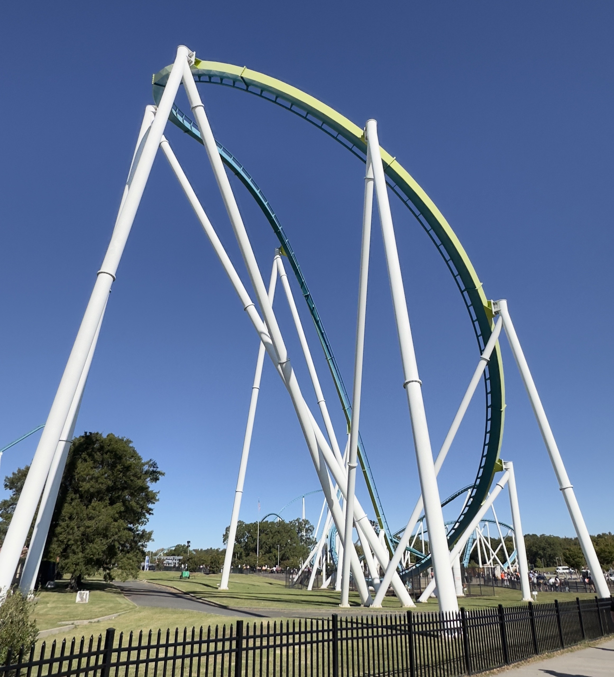 Fury 325's banked drop curve and white supports seen from the fence line, Carowinds, October 2024