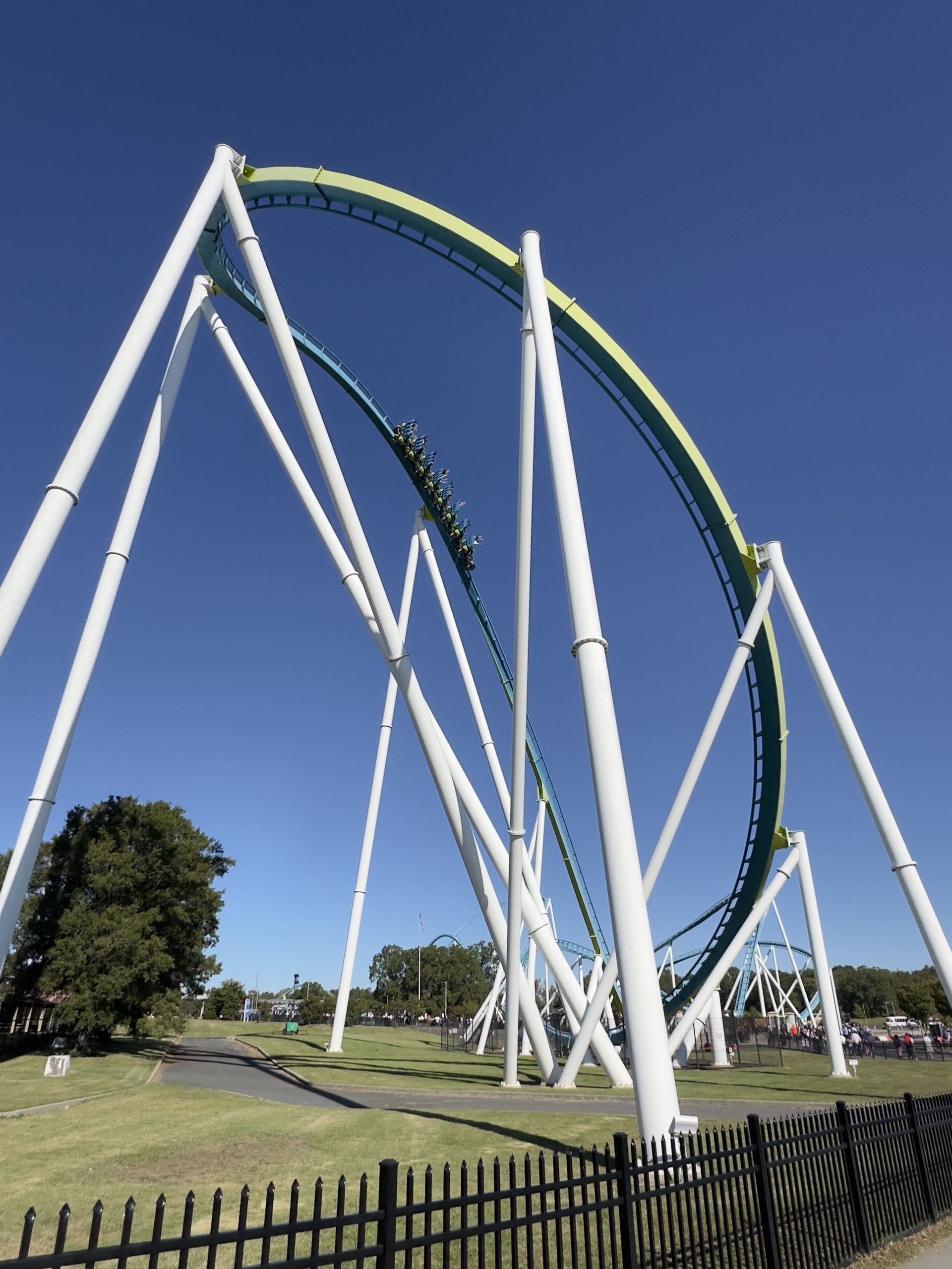 A Fury 325 train sweeping through the drop curve under the white supports, Carowinds, October 2024