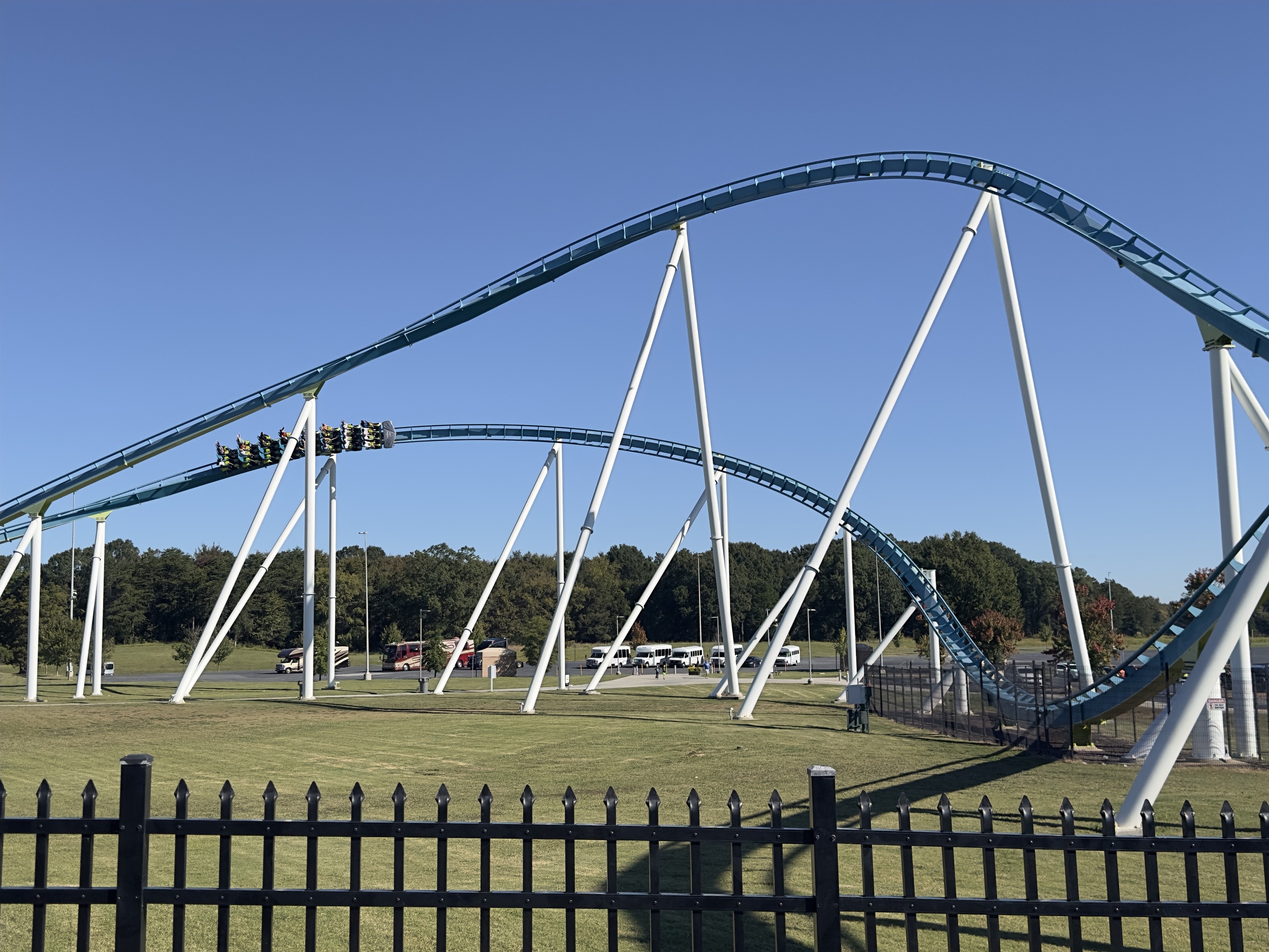 A Fury 325 train cresting a long airtime hill above the grass, Carowinds, October 2024