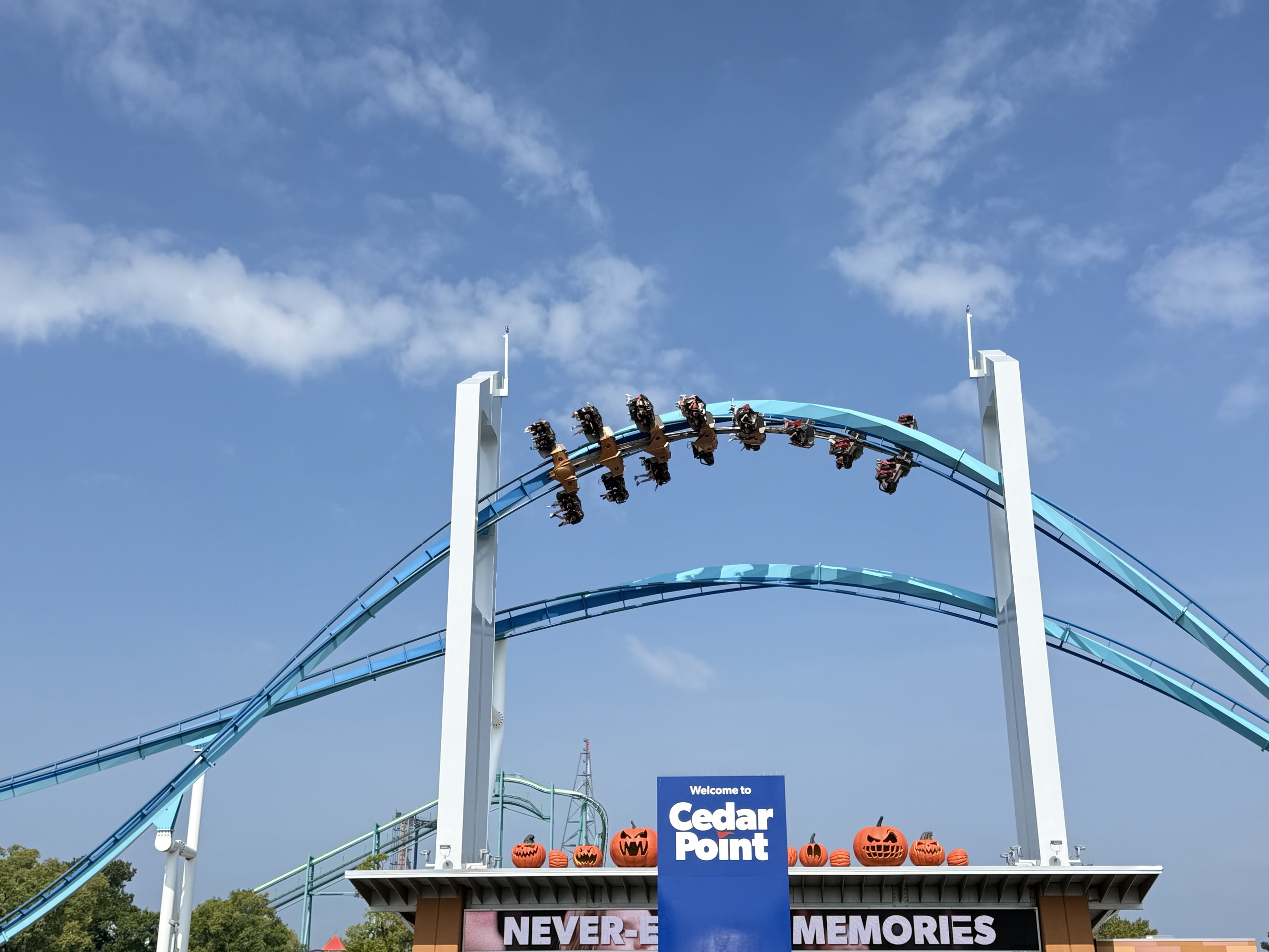 A GateKeeper train mid-inversion between the two keyhole towers over the Cedar Point entrance