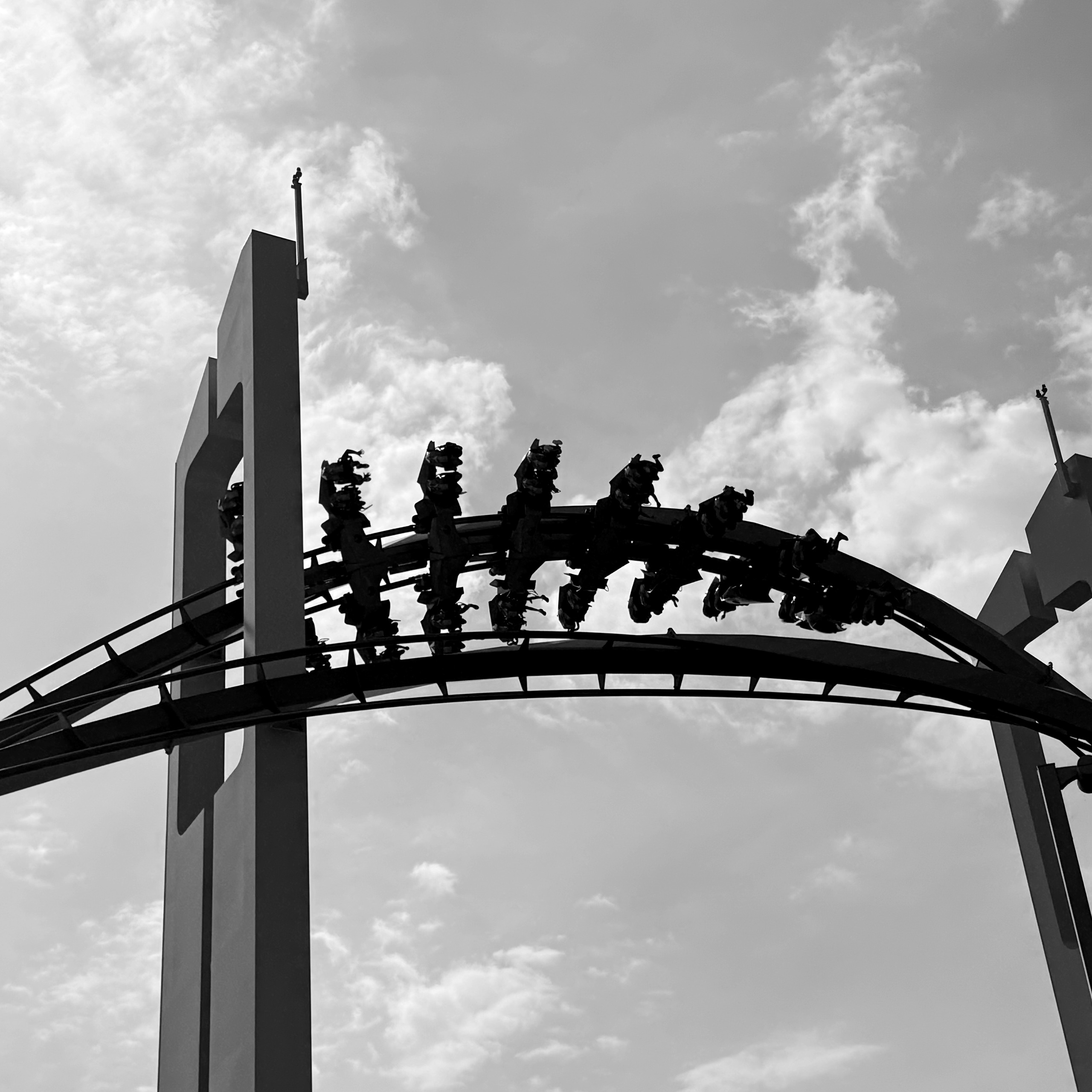 A GateKeeper wing coaster train silhouetted through the keyhole tower at Cedar Point, black and white