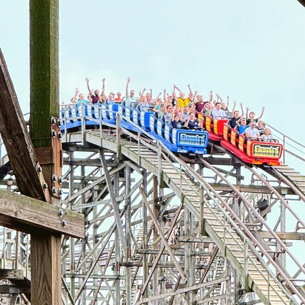 Gemini's red and blue trains cresting the hill side by side at Cedar Point, September 2026