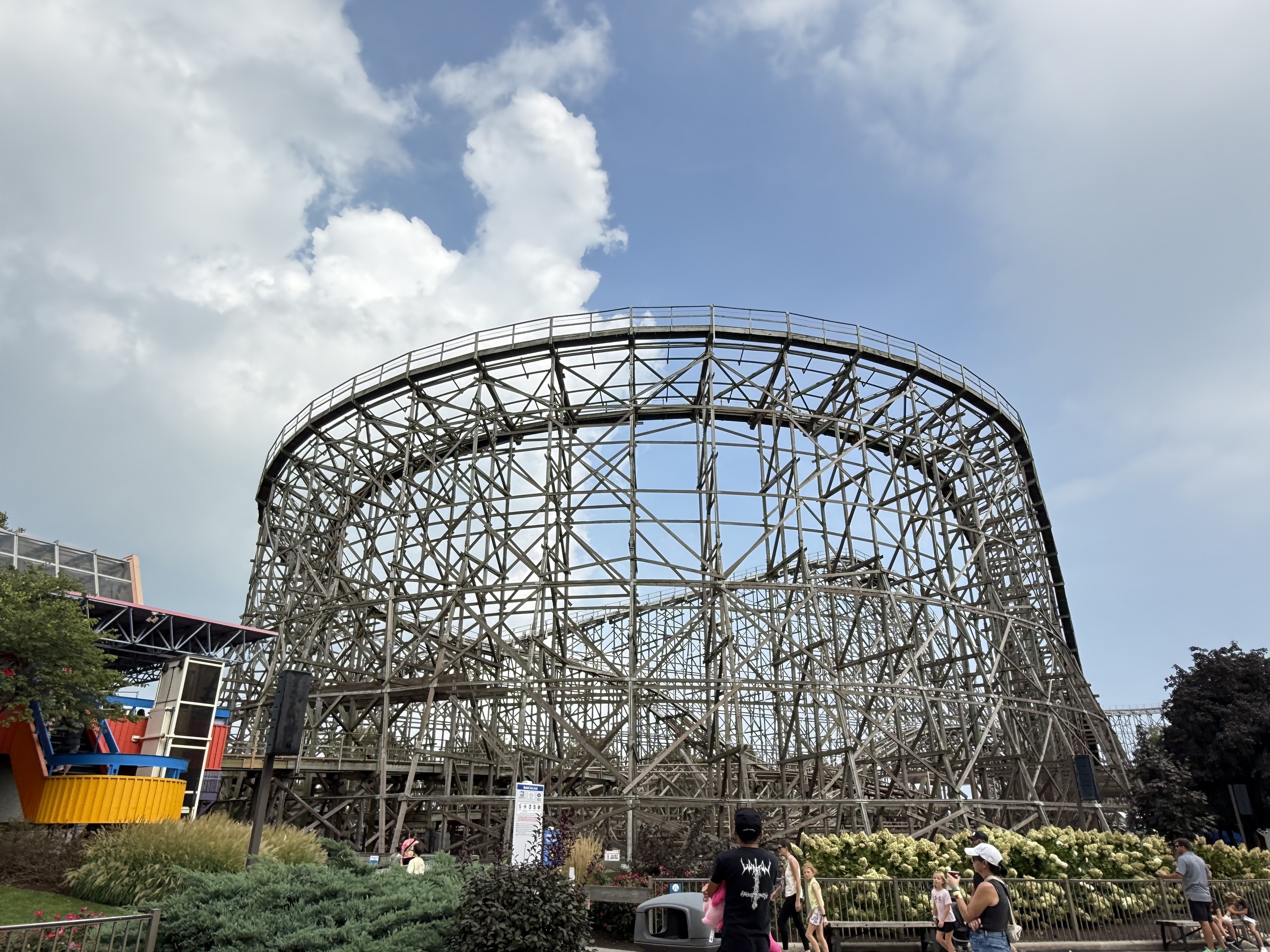 The tall wooden turnaround structure of Gemini against a cloudy sky at Cedar Point