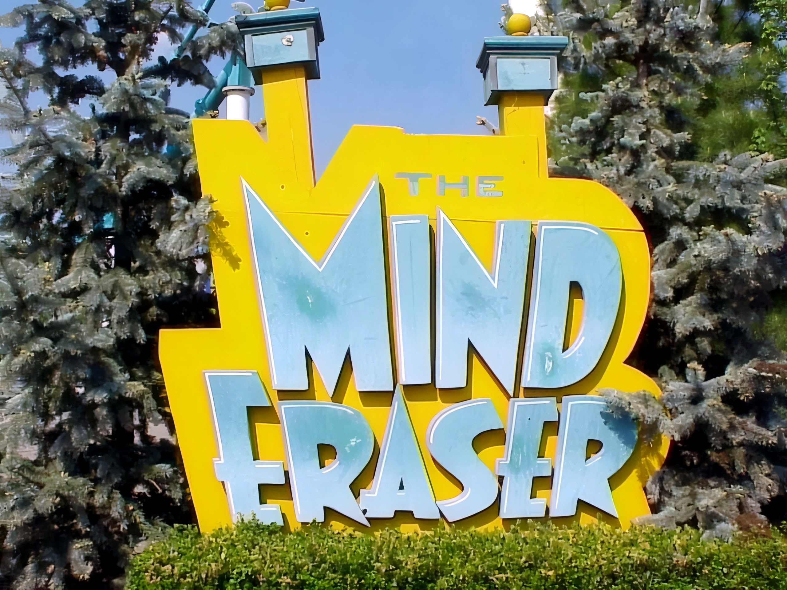 The Mind Eraser ride sign among the evergreens (the boomerang later renamed Head Spin) at Geauga Lake, May 2000
