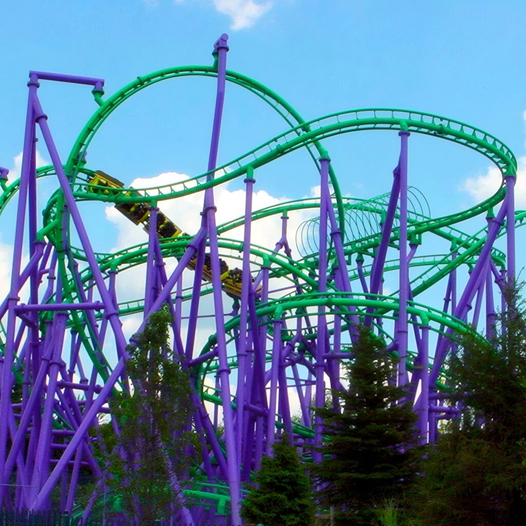 The Joker's Jinx at Six Flags America: a train threading the green track and purple supports