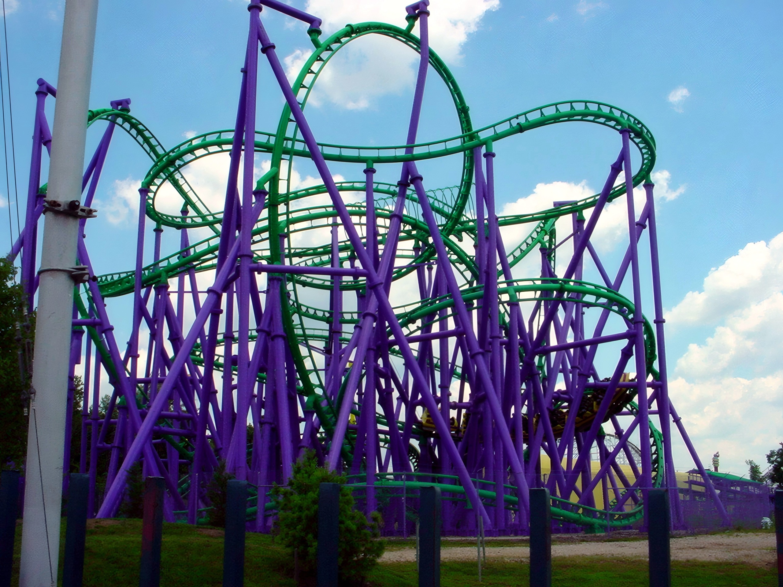 The Joker's Jinx green track and purple supports against the clouds at Six Flags America, July 2001