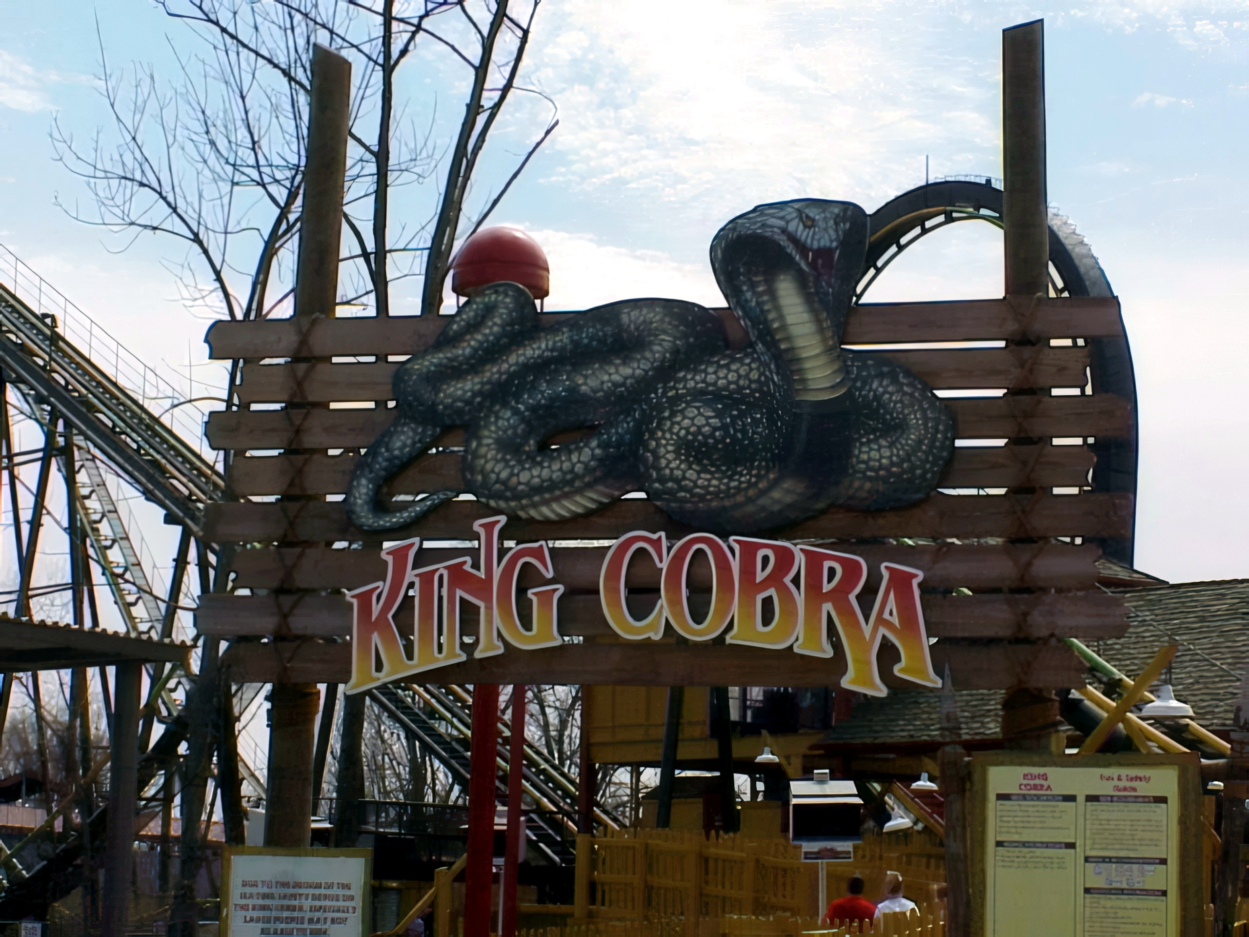 The King Cobra entrance sign with its cobra sculpture and the track behind at Paramount's Kings Island, April 2001
