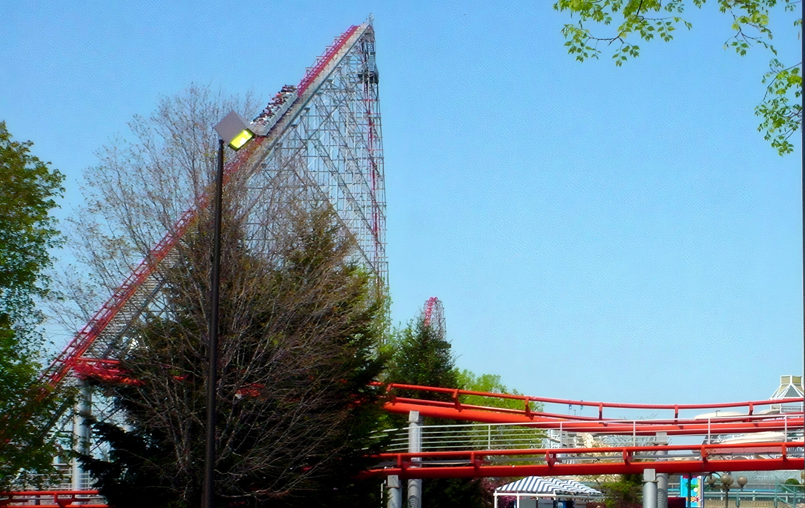 The Magnum XL-200 lift hill and first drop from the midway with the red track crossing overhead at Cedar Point, May 2002