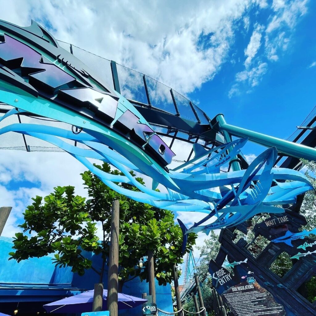 Mako's blue shark sculptures and wave decoration under the track and station canopy, SeaWorld Orlando, March 2021