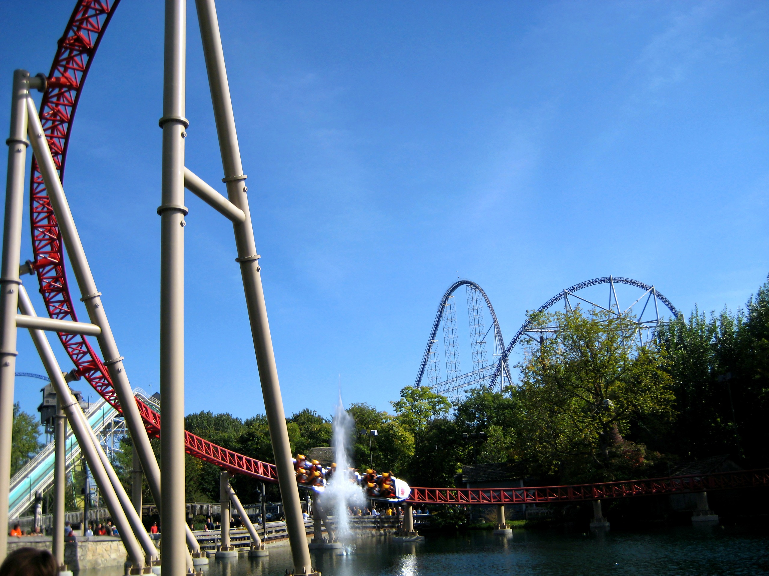 A Maverick train racing past the lake with Millennium Force behind at Cedar Point, September 2007