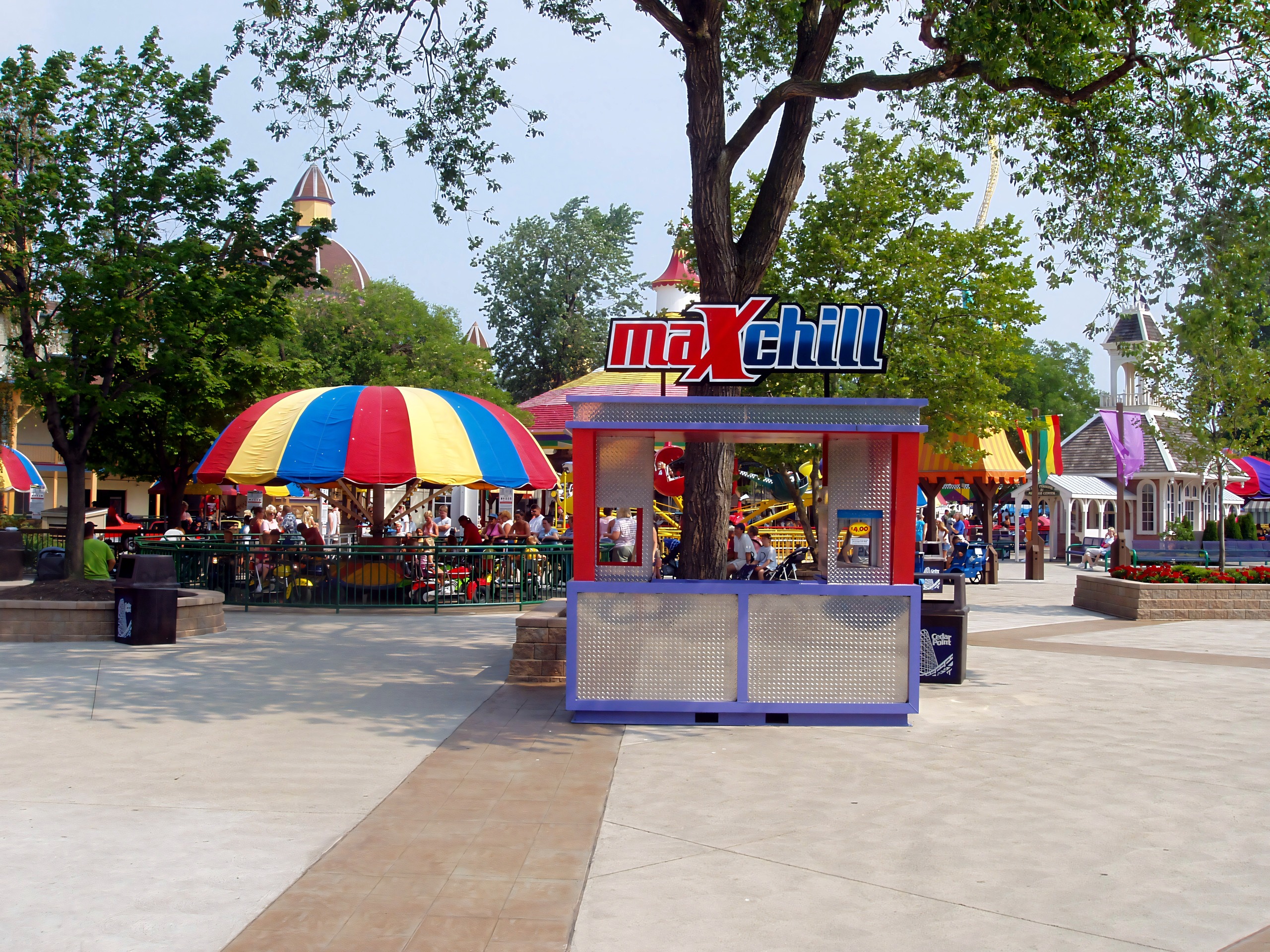 The maXchill kiosk beside a umbrella-topped kids' ride on a Cedar Point midway, July 2005