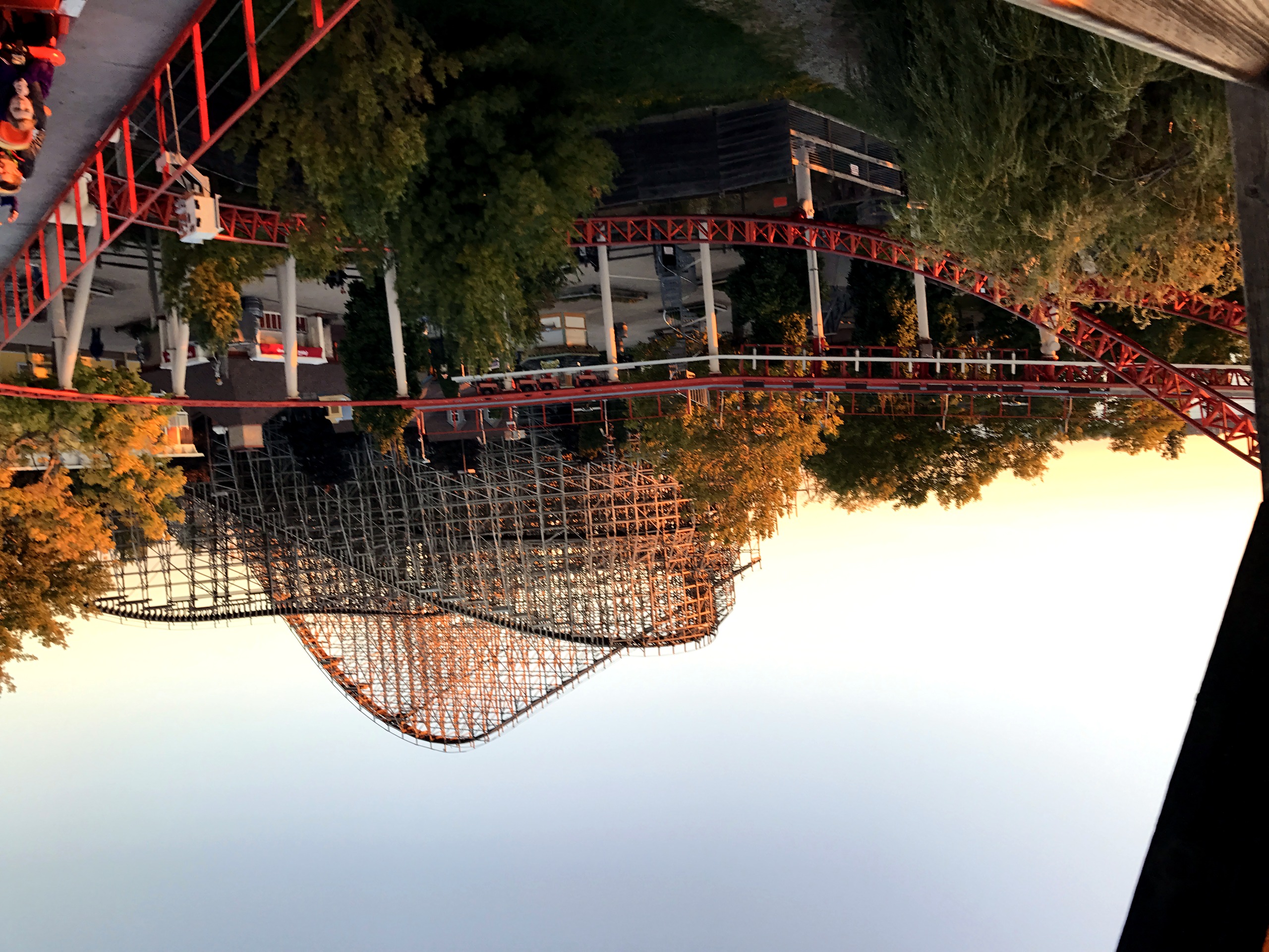 Wooden roller coaster structure at sunset, riders visible, Mean Streak, October 2016