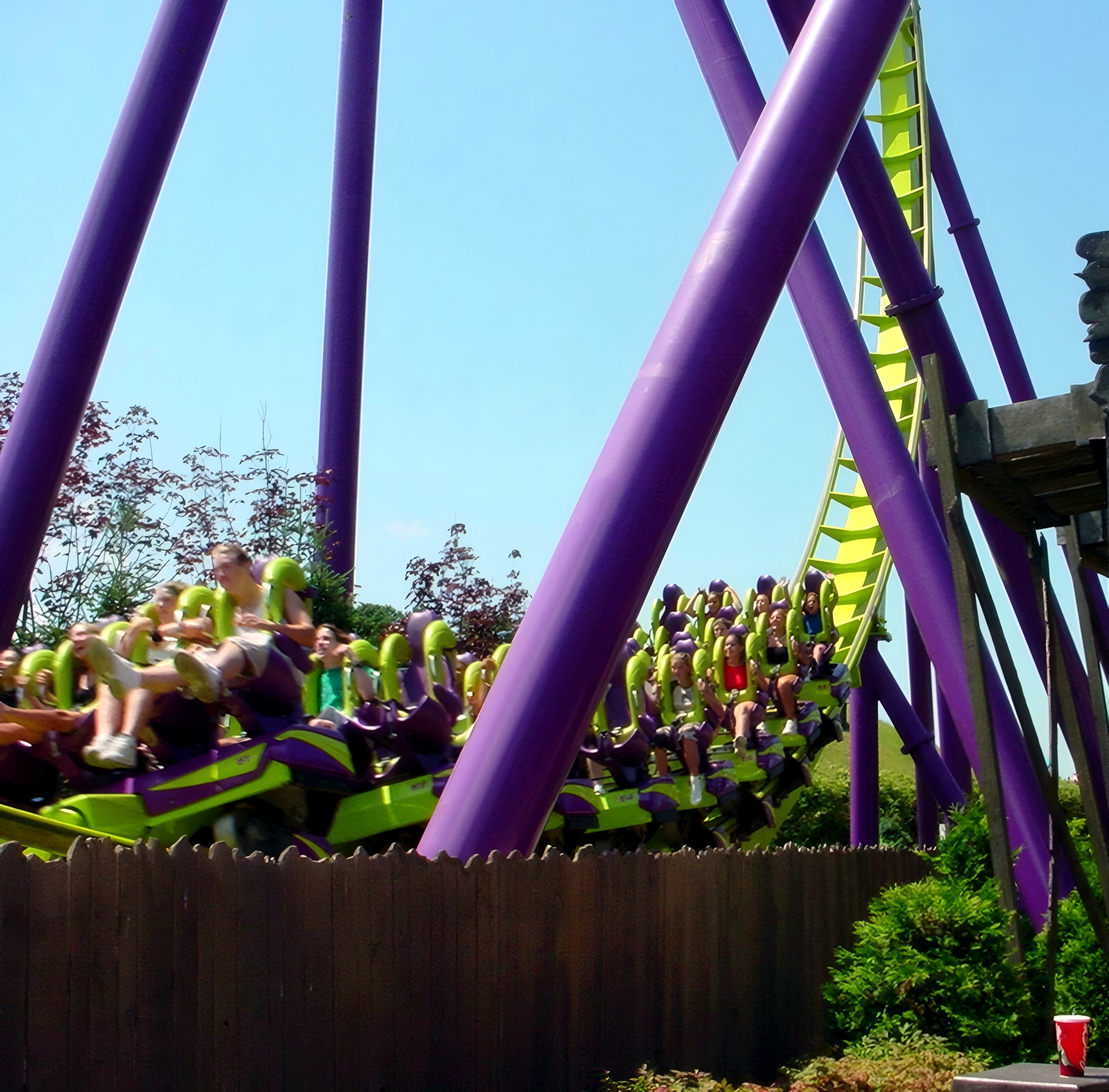 Riders' legs dangling from a Medusa train passing the station at Six Flags Great Adventure, July 2001