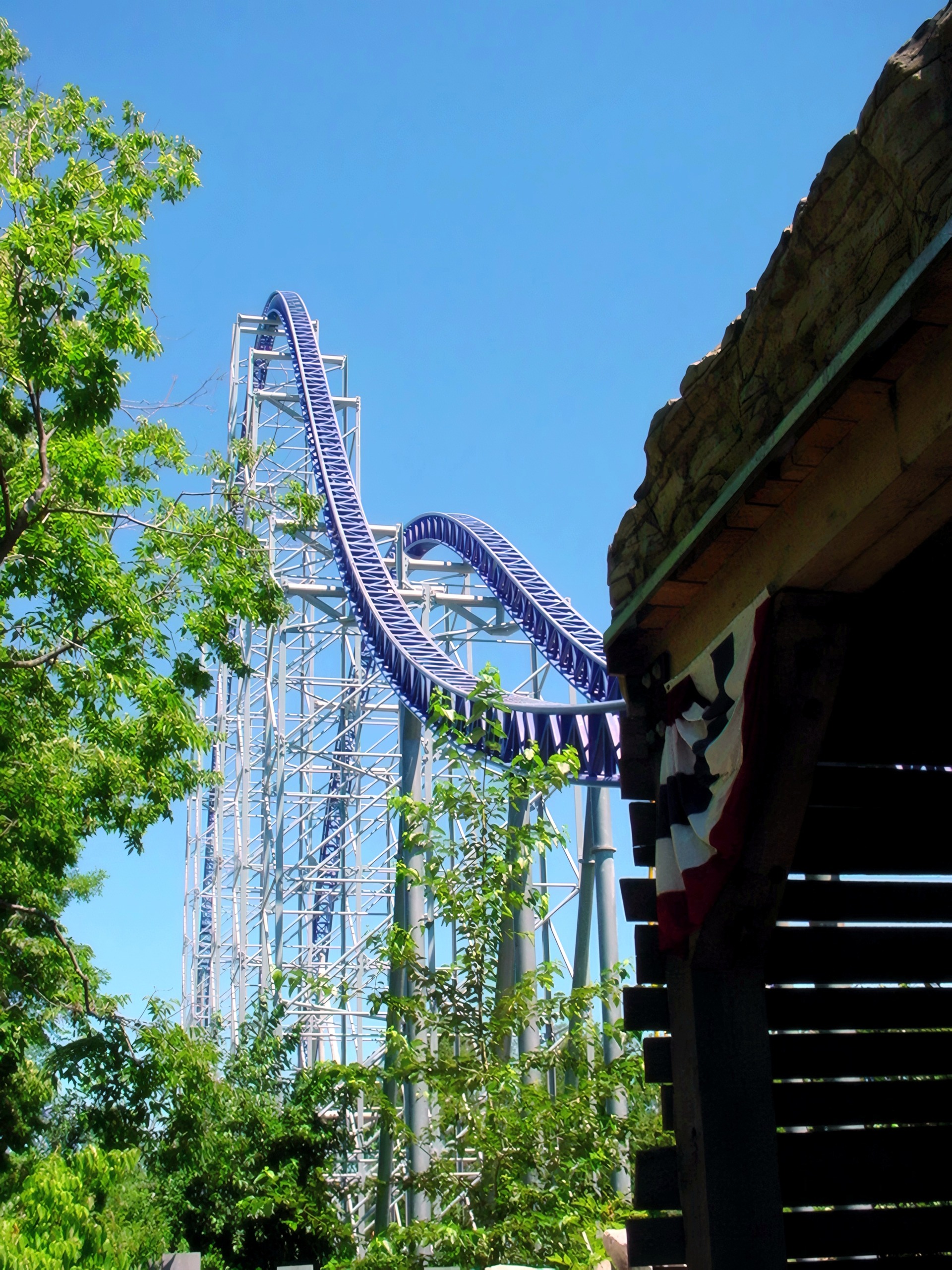 Blue coaster loop and lift hill seen past rocky facade, Millennium Force, July 2003