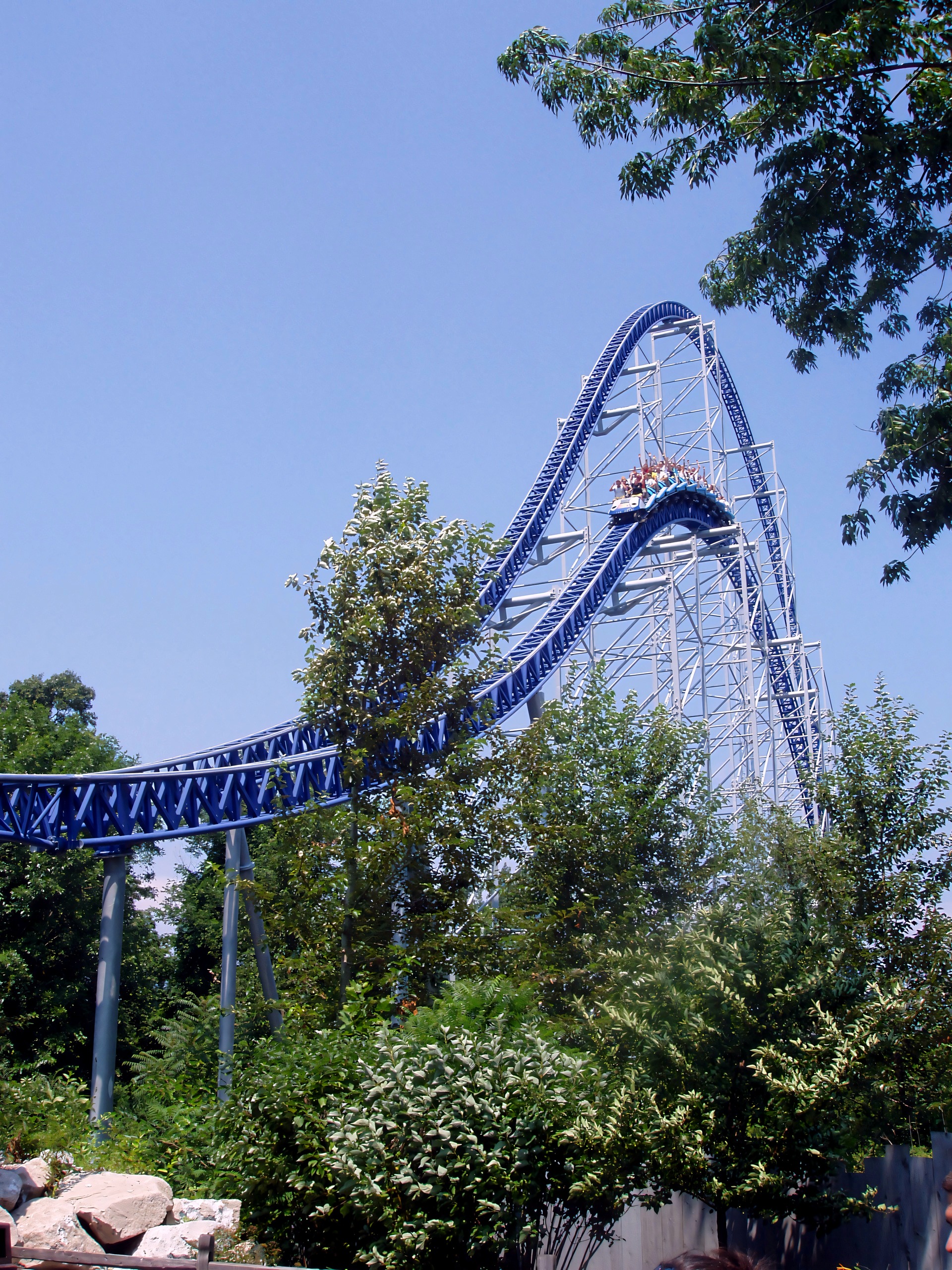 Blue coaster train cresting hill against blue sky, Millennium Force, July 2005