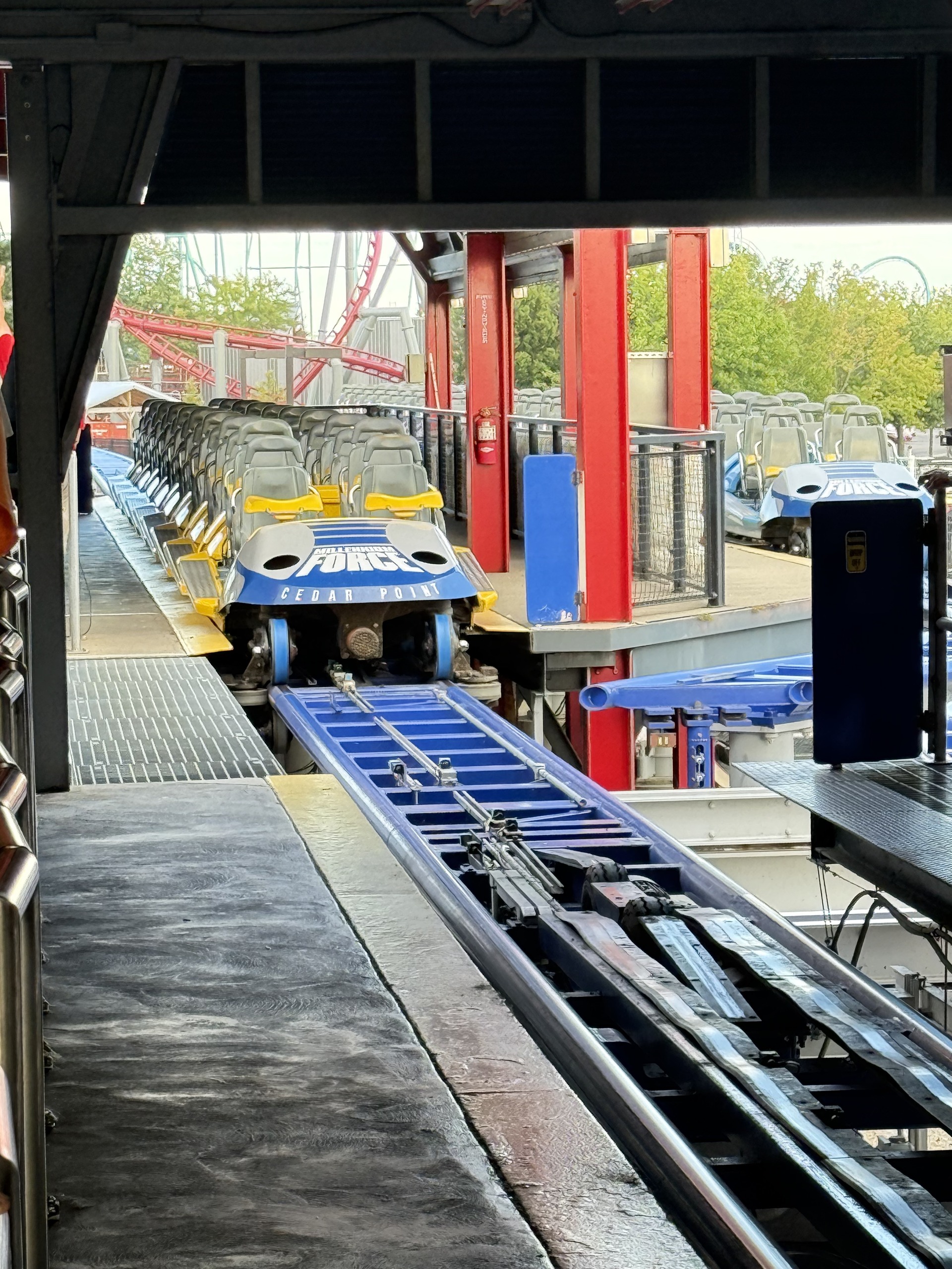 A Millennium Force train with its logo nose entering the station