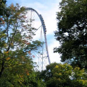 A Millennium Force train climbing the 310-foot lift hill, framed by early-fall trees at Cedar Point, September 2007