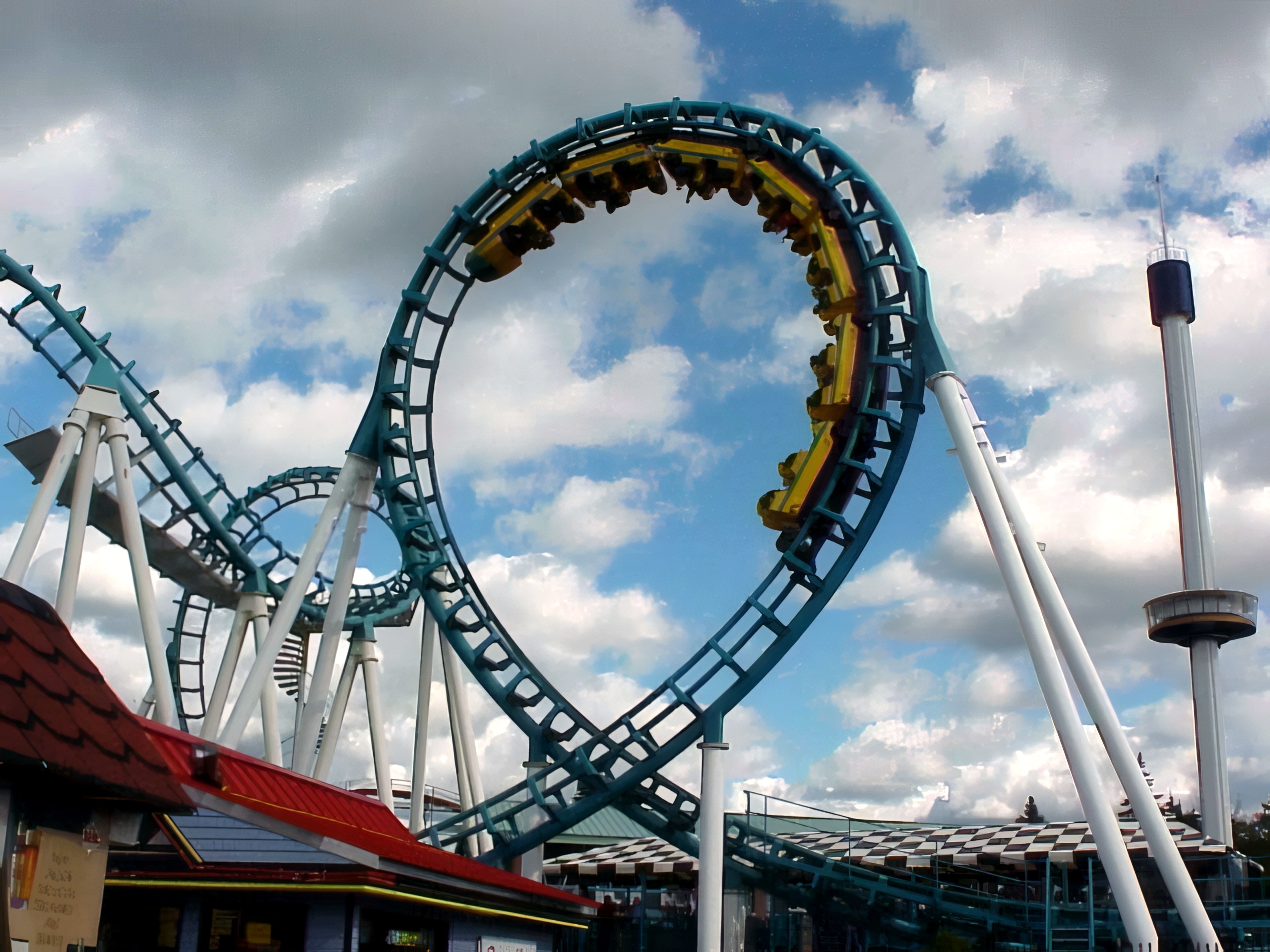 The Mind Eraser boomerang's teal vertical loop with a yellow train above the midway at Six Flags Ohio, 2000