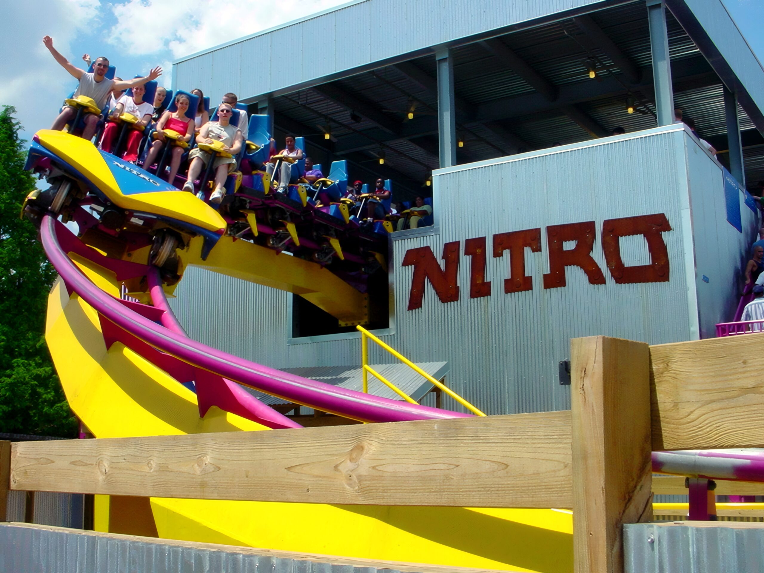Riders with their arms up on a Nitro train near the station, July 2001