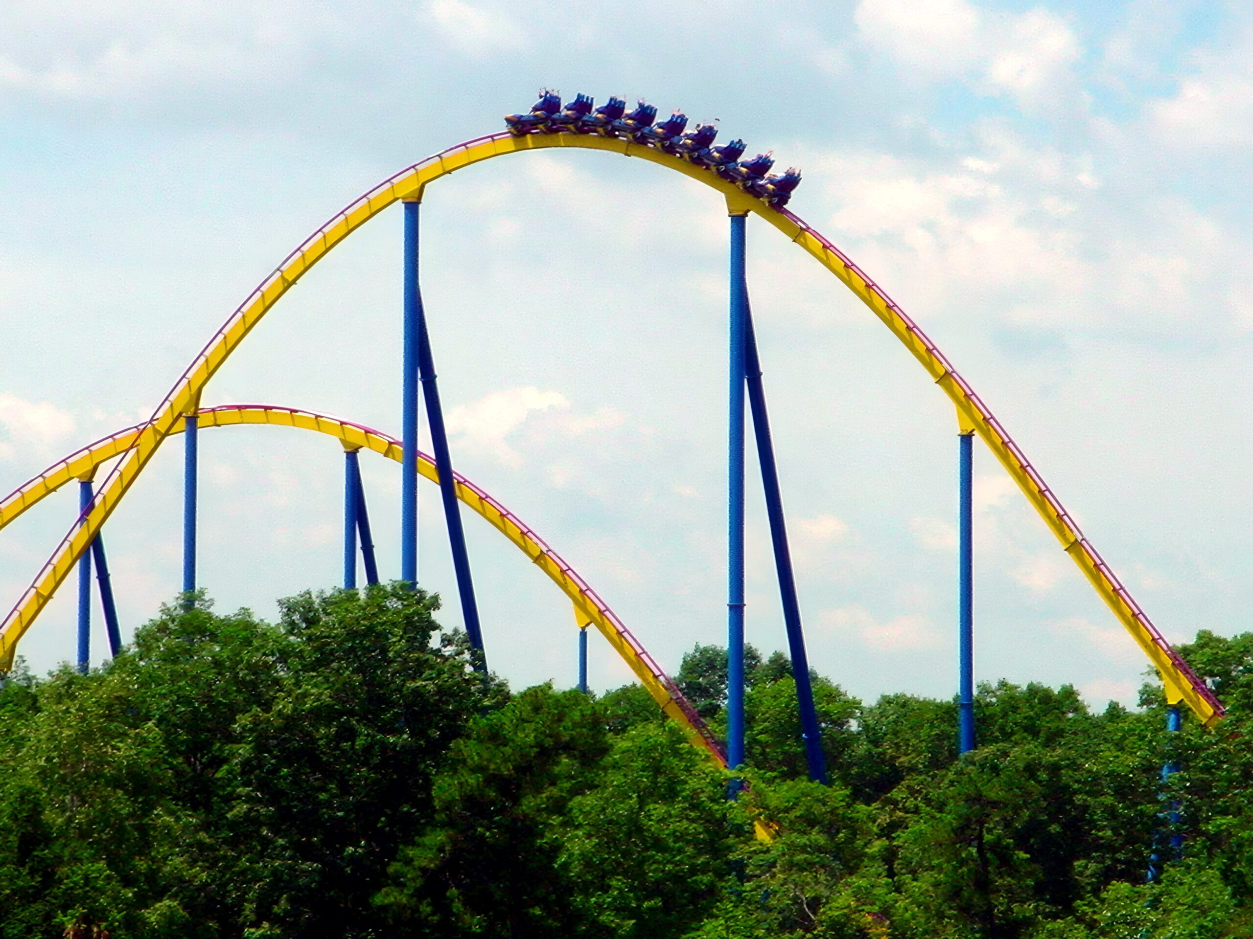 A Nitro train cresting a camelback hill above the trees, July 2001