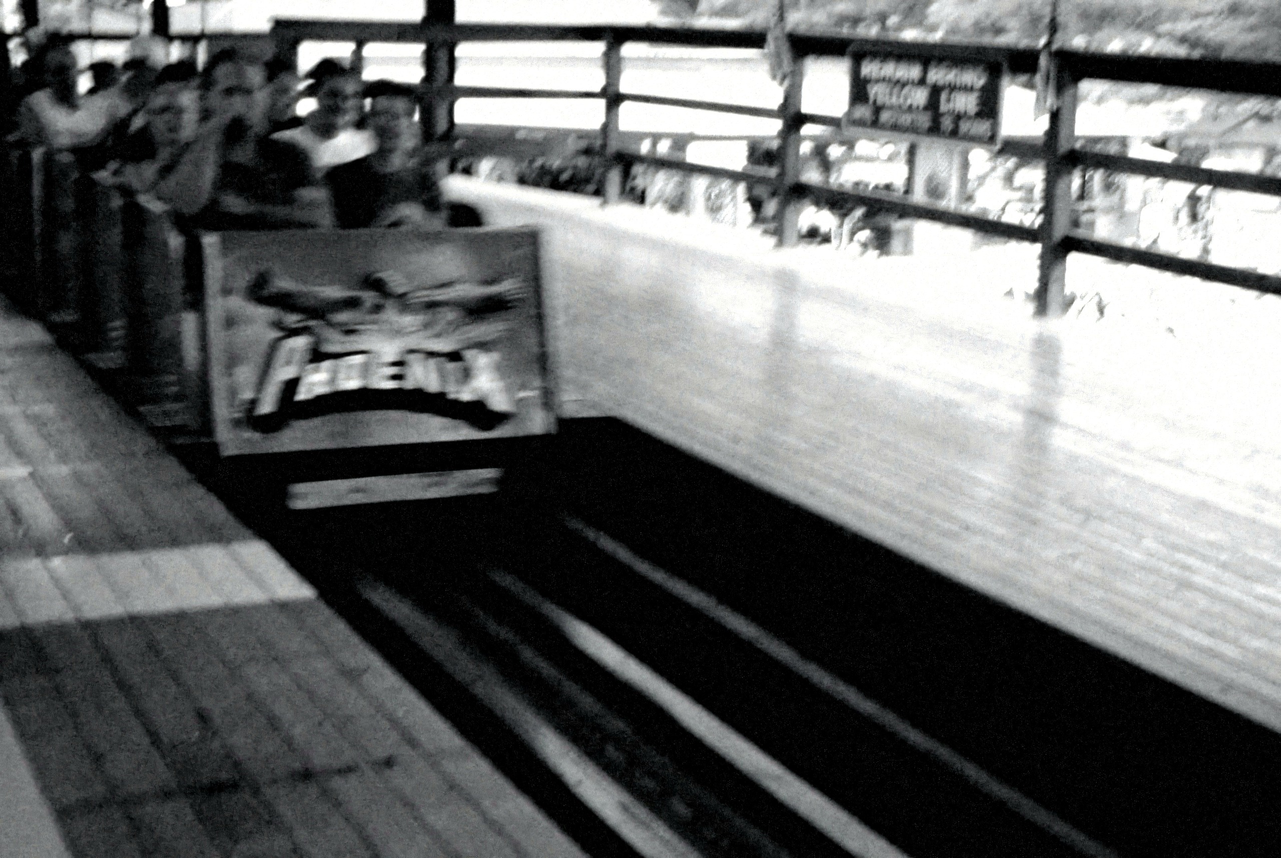 A Phoenix train blurring past on the lift, black-and-white film-grain edit, July 2003