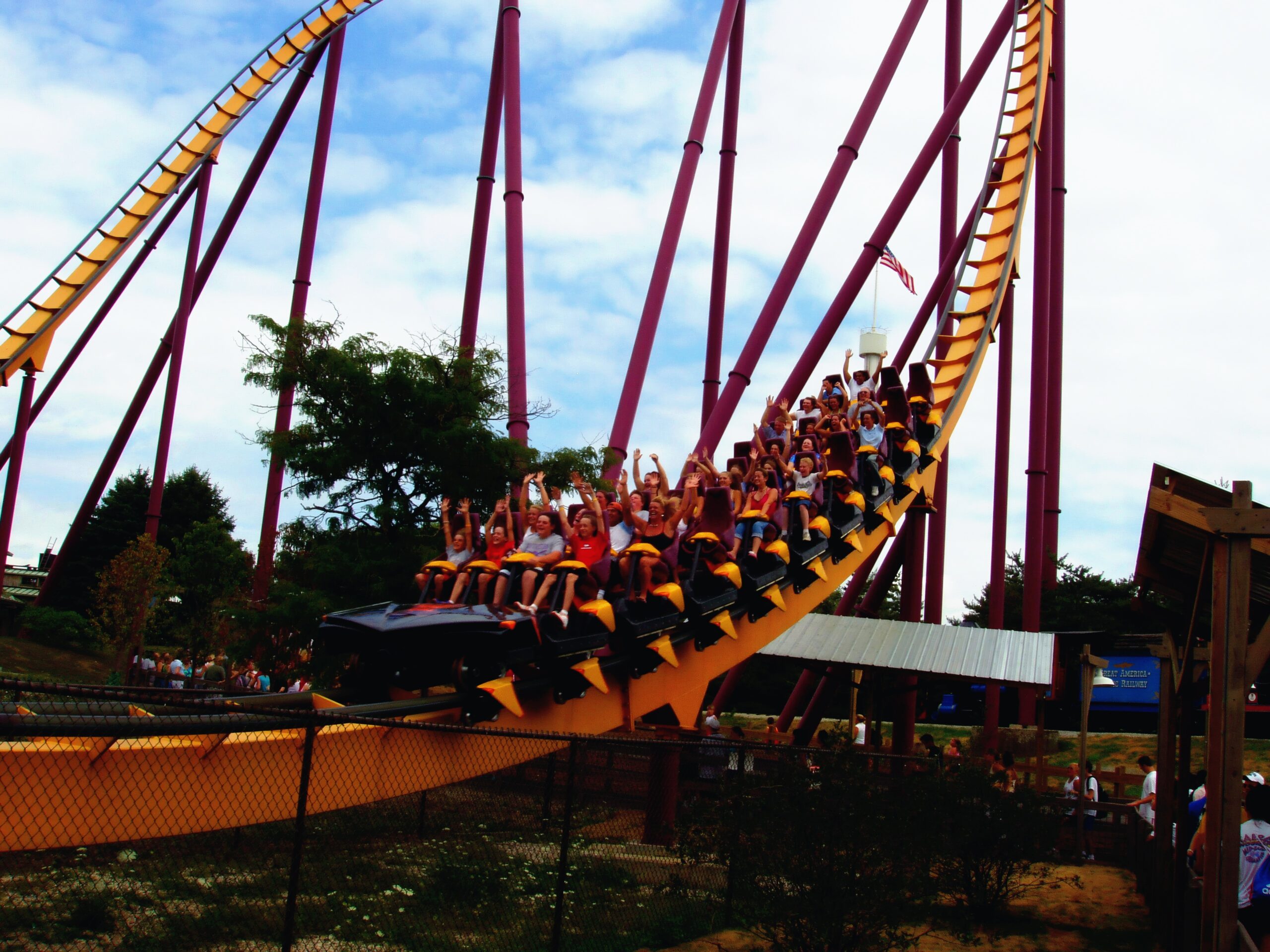 A Raging Bull train full of riders with their hands up sweeping through the valley at Six Flags Great America