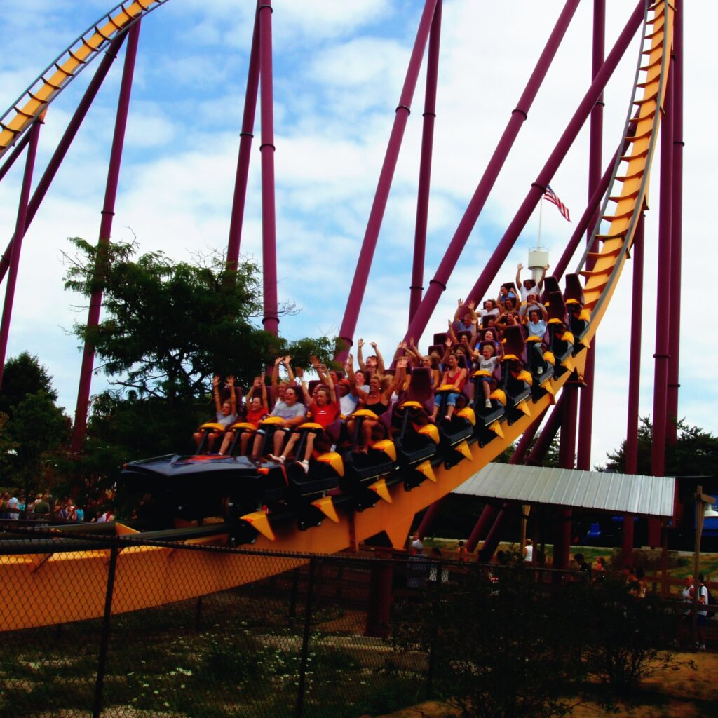 A Raging Bull train full of riders with their hands up sweeping through the valley at Six Flags Great America