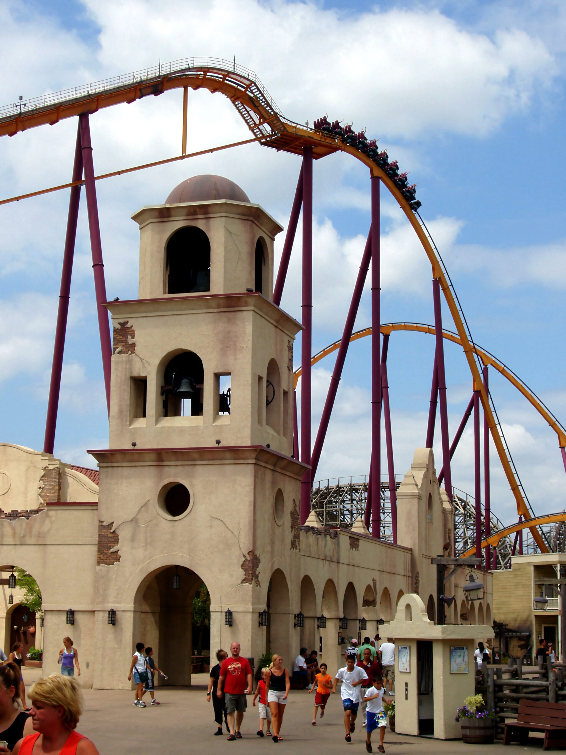 Raging Bull roller coaster track and train arcing over the Southwest Territory bell tower at Six Flags Great America