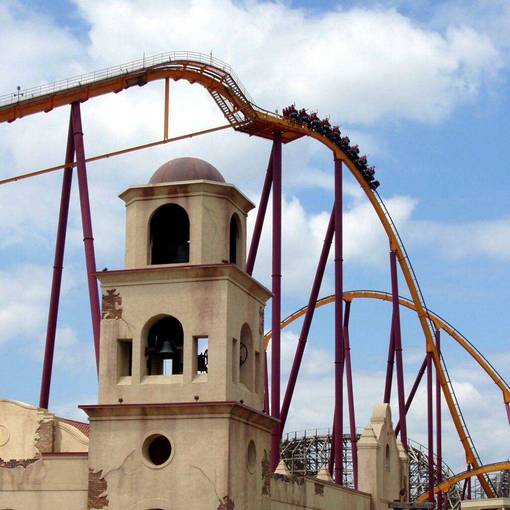 Raging Bull roller coaster track and train arcing over the Southwest Territory bell tower at Six Flags Great America
