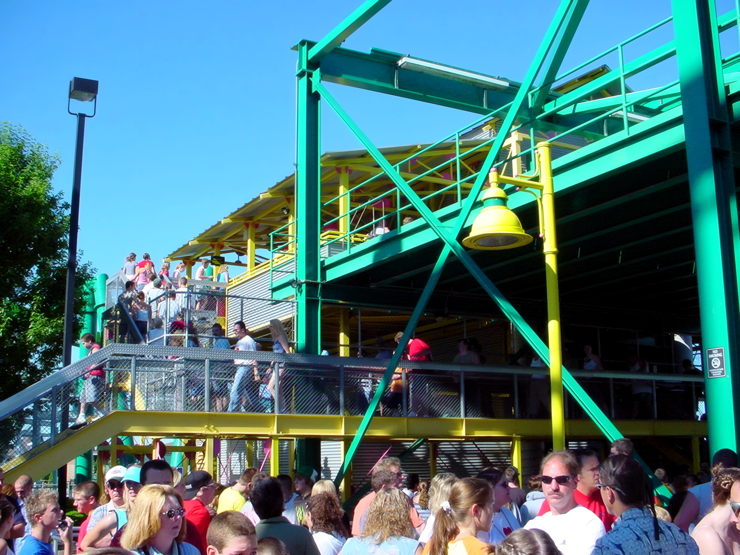 Crowd boarding green and yellow coaster station, Raptor, July 2003