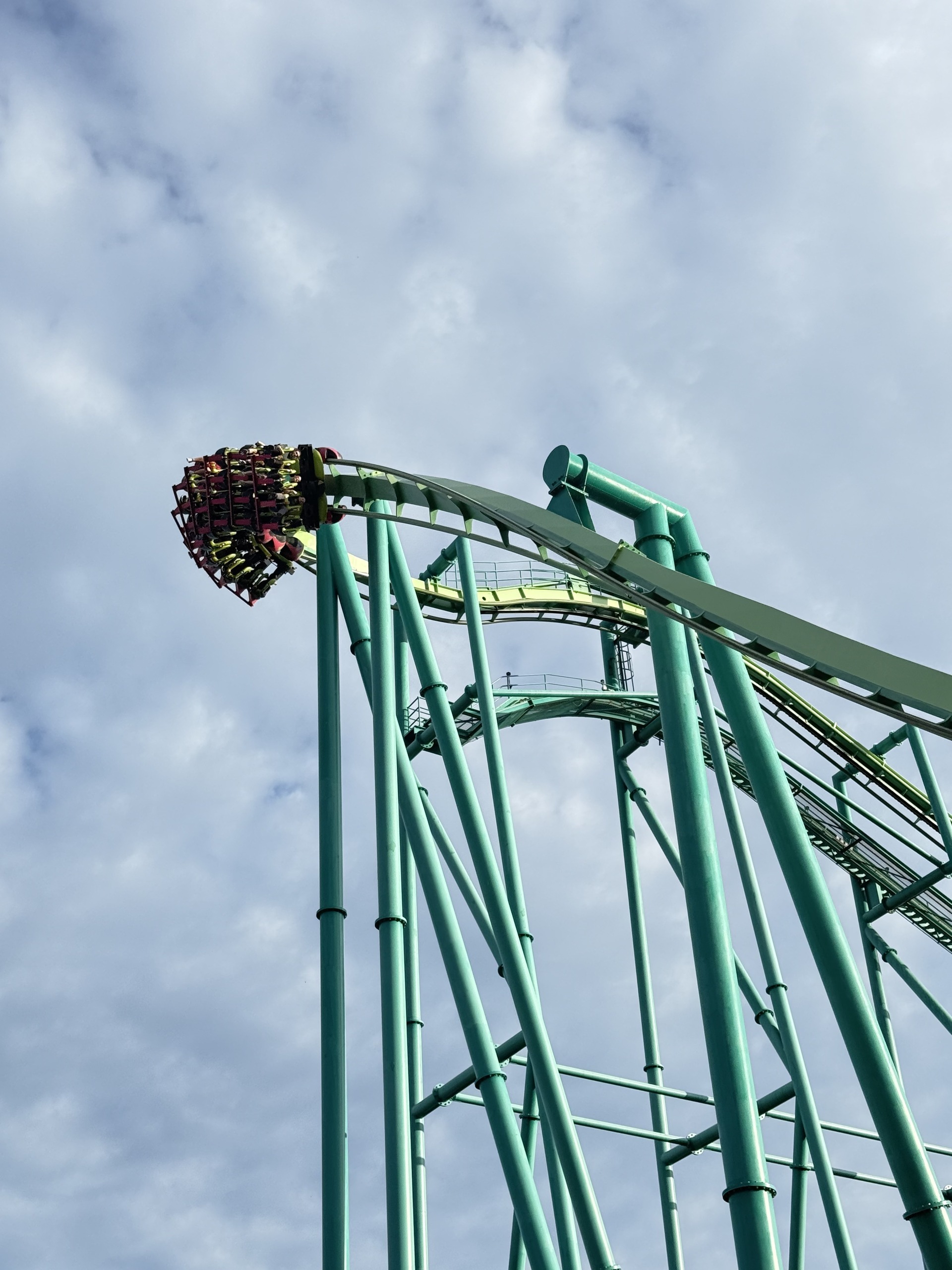 A Raptor train dropping off the green lift hill crest in evening light