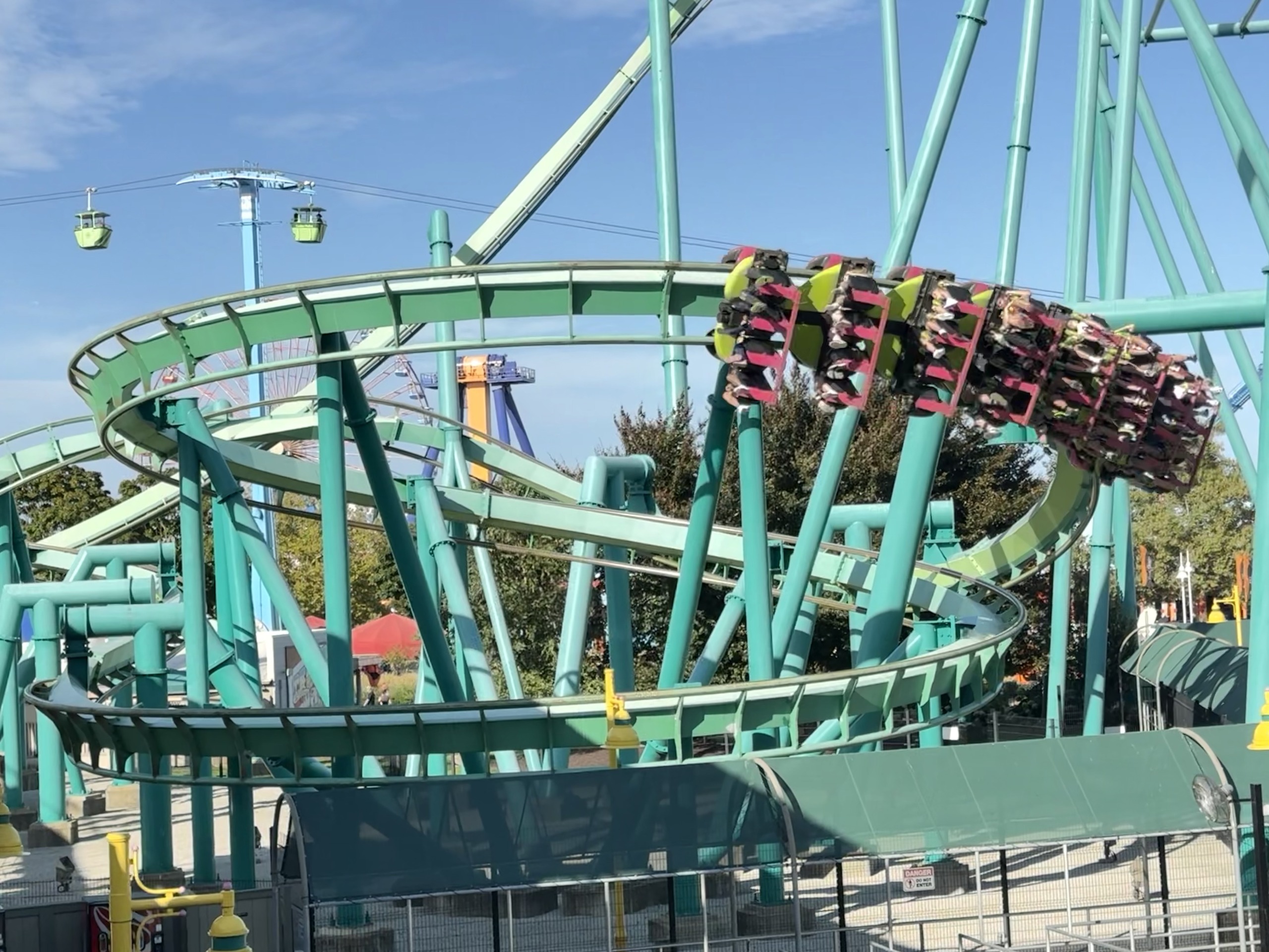 A Raptor inverted train mid-helix with riders' legs dangling, seen from close below