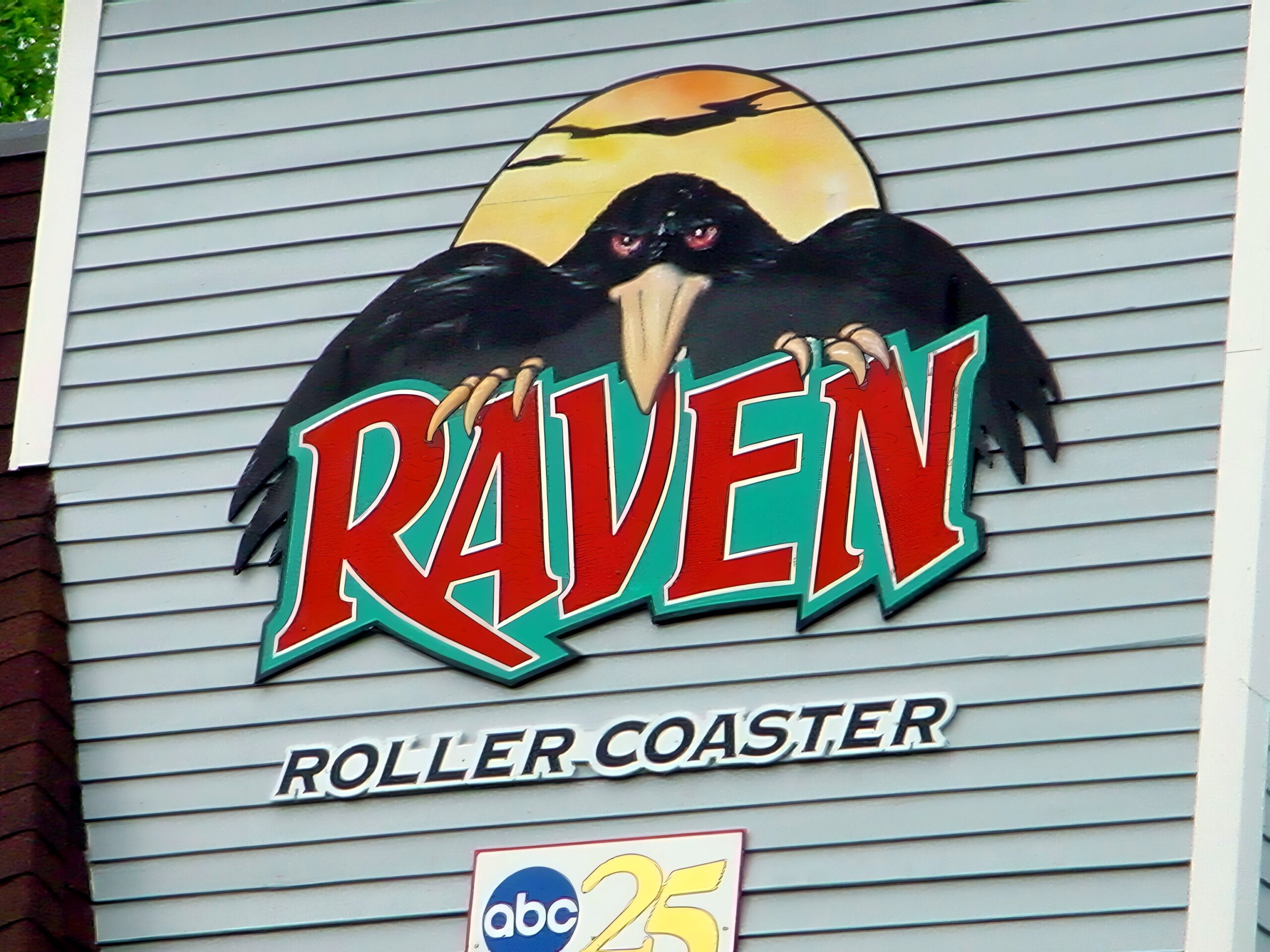 Close-up of The Raven roller coaster logo on the station, July 2002